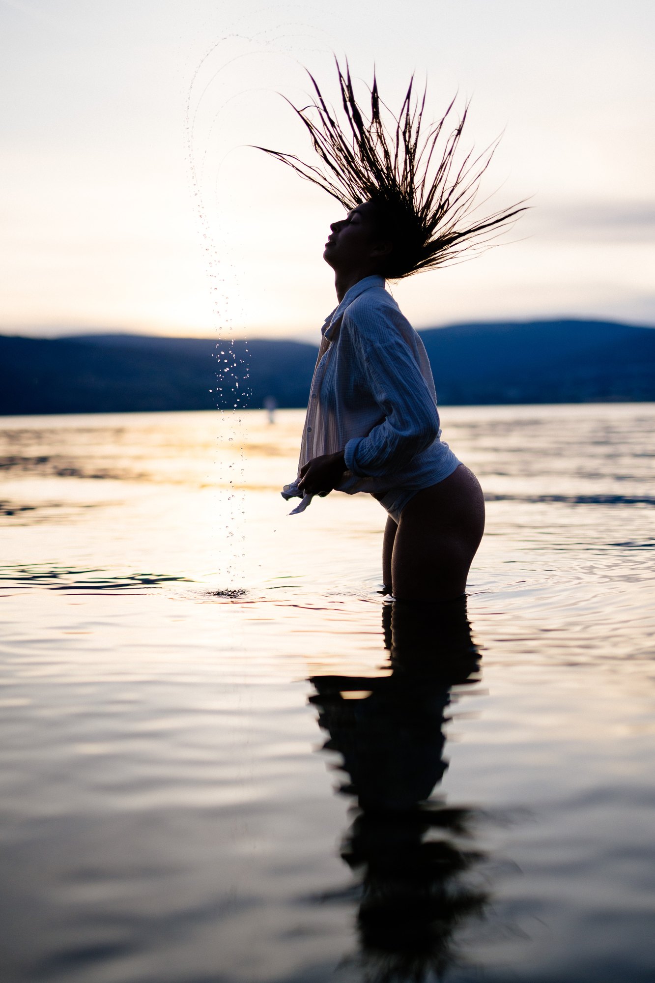 Karly — hair flipping in a sharp arc against the evening sky