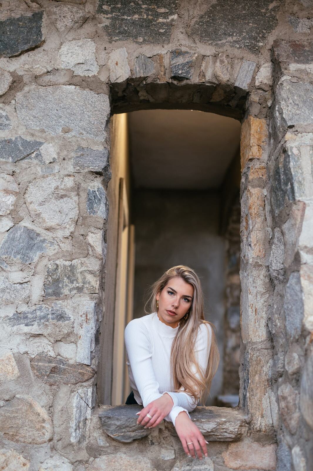Kaylee at Lier House portraits story frame 19: Penticton portraits for Kaylee at Lier House, moving from window light and interior texture into stone steps, pale winter colour and quiet exterior portrait range.