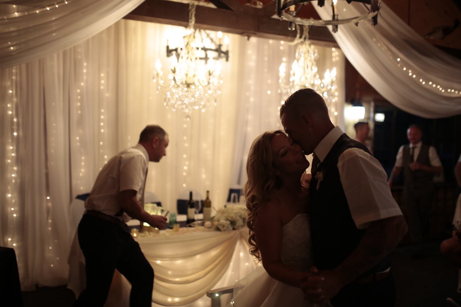Kendra and Mike story frame 8: An older wedding story with lake dusk, warm room light, speeches, dancing and a full-day feeling.
