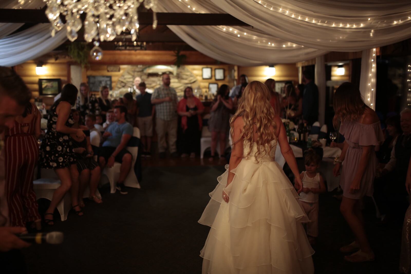 Kendra and Mike story frame 10: An older wedding story with lake dusk, warm room light, speeches, dancing and a full-day feeling.