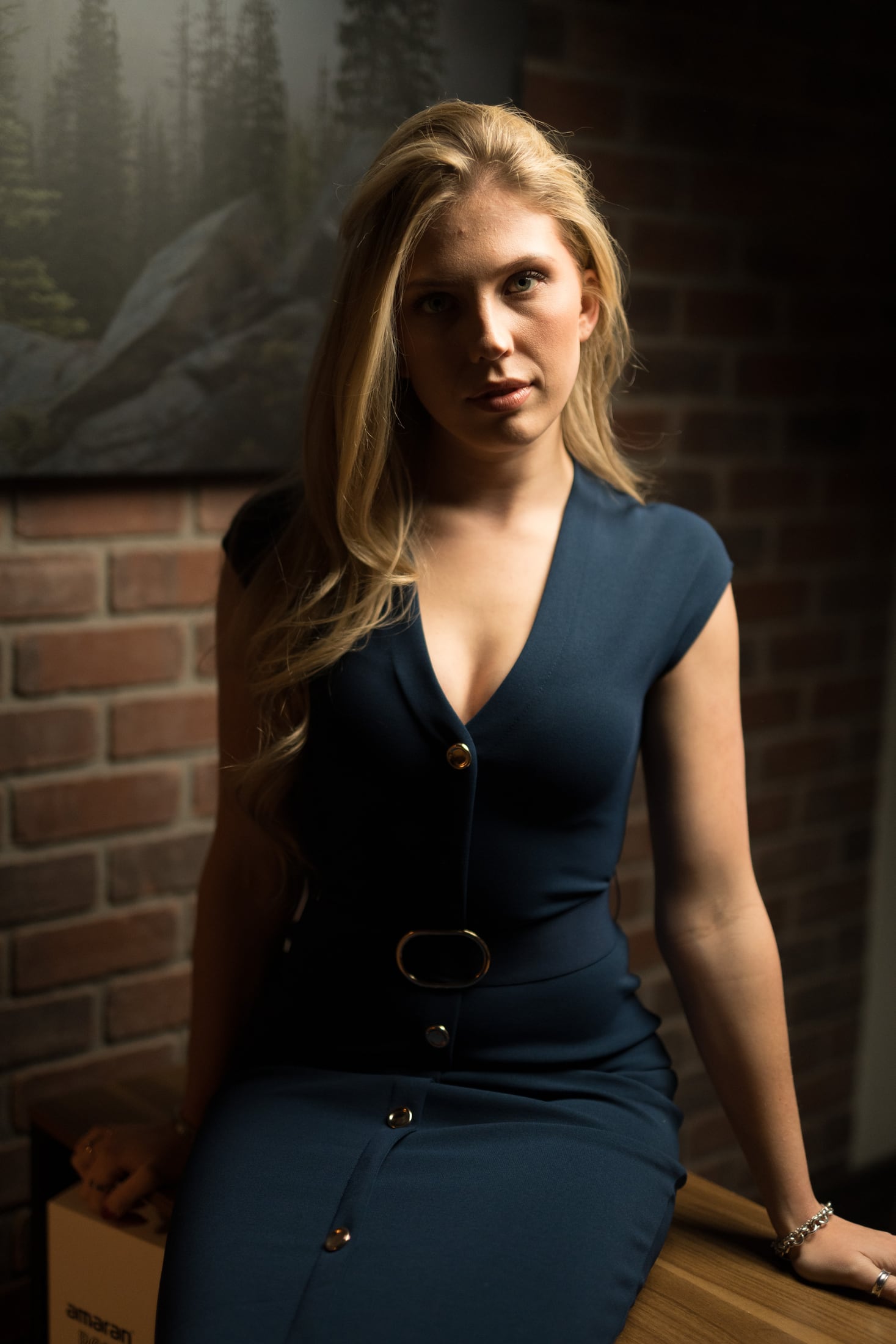 Kennedy standing beside a brick wall in window light