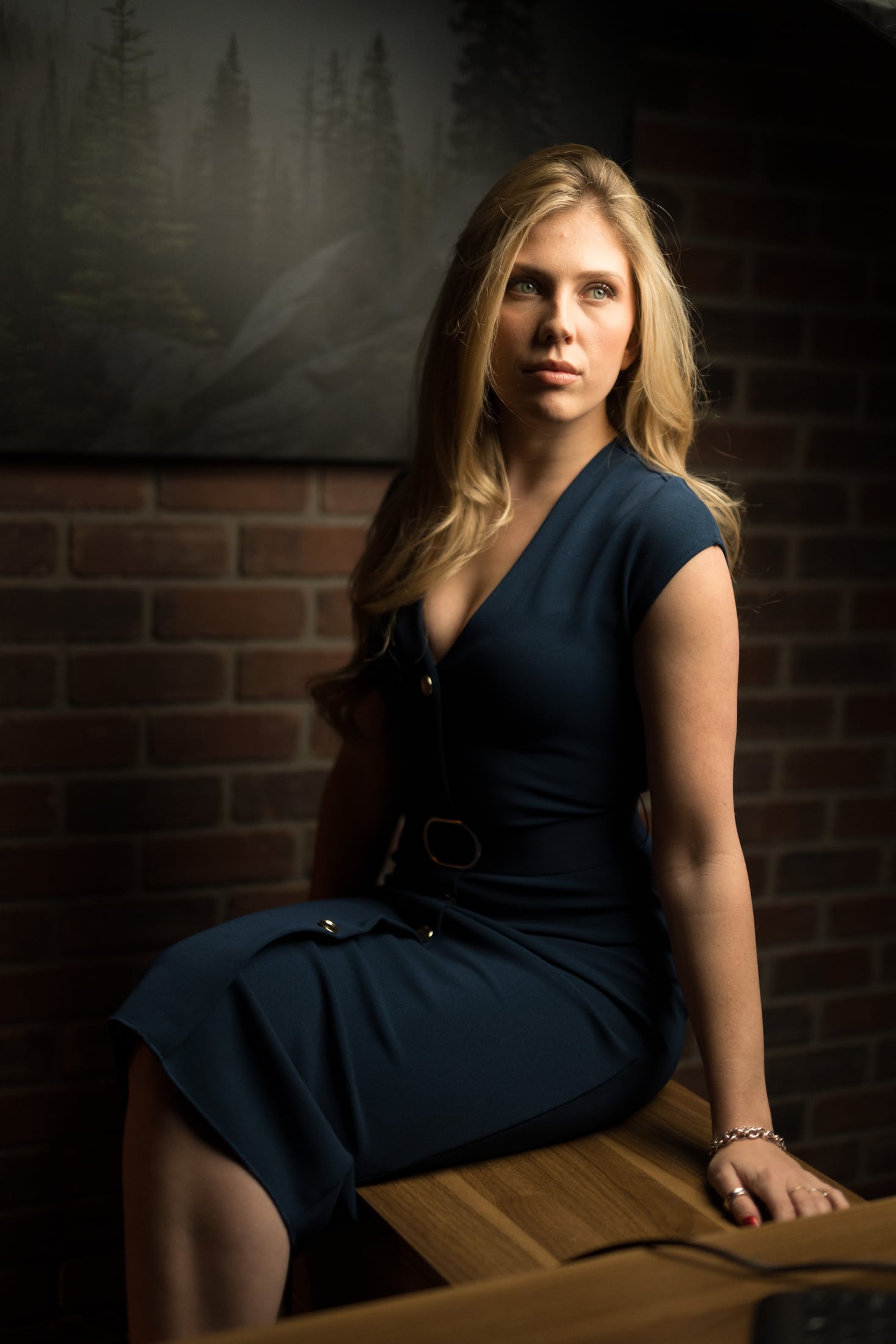 Kennedy looking into the camera while seated in a navy dress