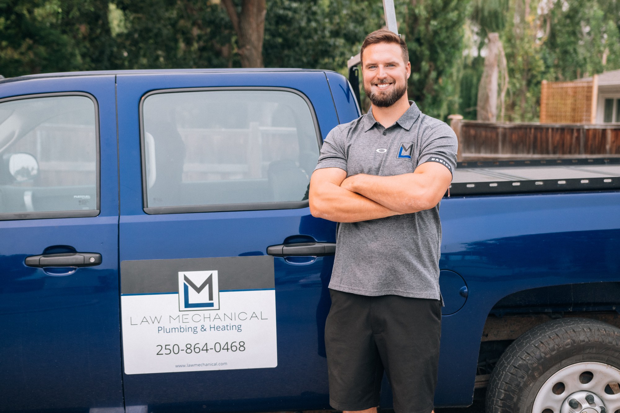 Alex beside the blue Law Mechanical work truck.