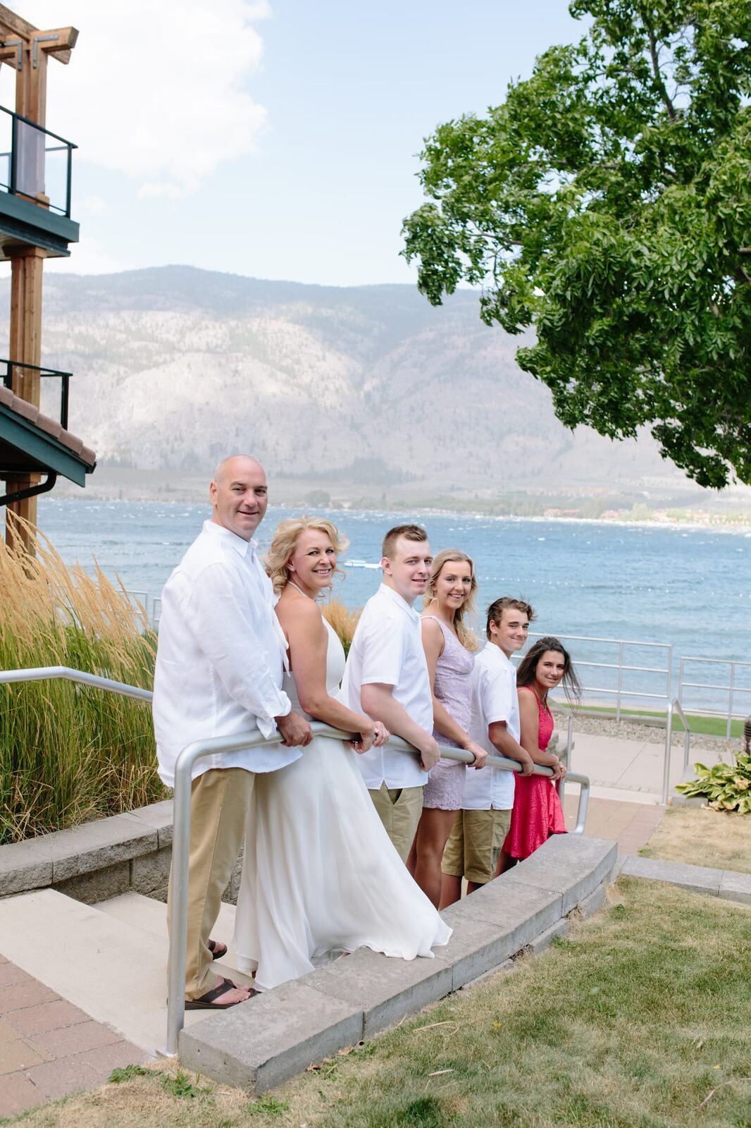 Leeanne and Kelly weddings story frame 2: A Watermark Beach Resort wedding in Osoyoos, built around lakefront context, grown-family connection and careful, big-hearted coverage..