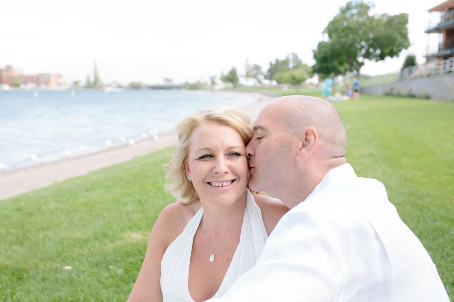 Leeanne and Kelly weddings story frame 5: A Watermark Beach Resort wedding in Osoyoos, built around lakefront context, grown-family connection and careful, big-hearted coverage..