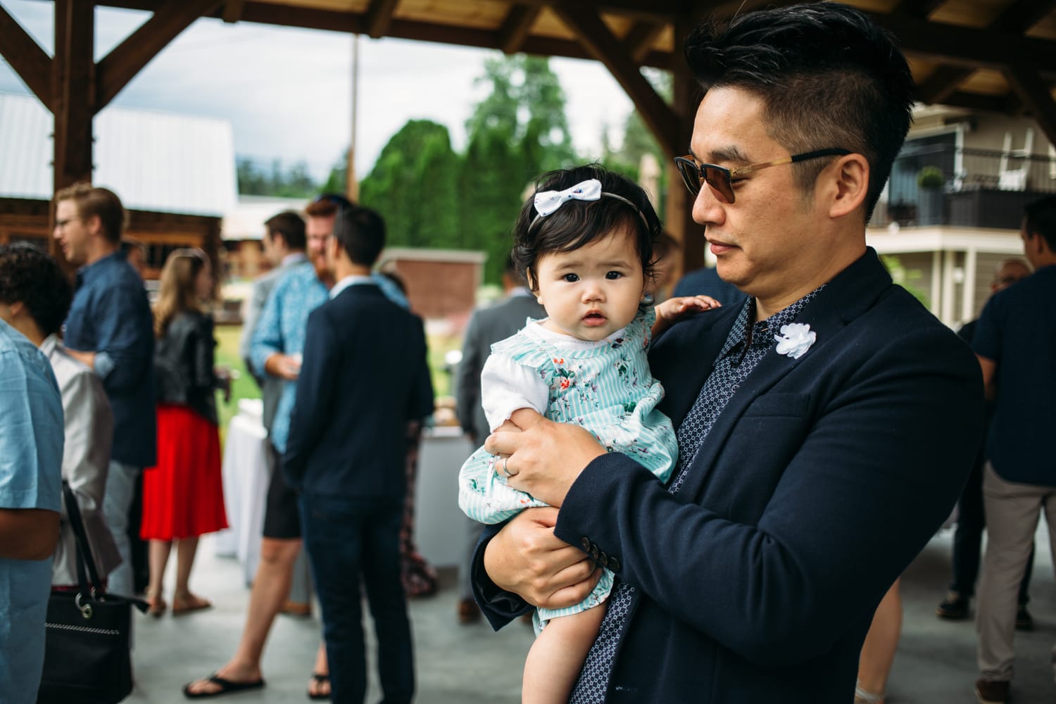 Leslie and Gerome weddings story frame 12: A Brook & Barn - Casorso Heritage Farm wedding in Kelowna, with orchard details, outbuildings, lawn games and a familiar friend-party feeling..