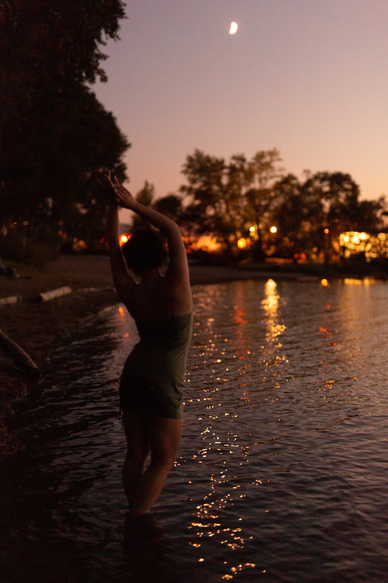 Lucy at the Water’s Edge portraits story frame 20: Lucy at the water’s edge as sunset slips into moonlight, moving from the shoreline and rocks to quiet close portraits and a warm-lit garden after dark. Photographed in Kelowna, BC.