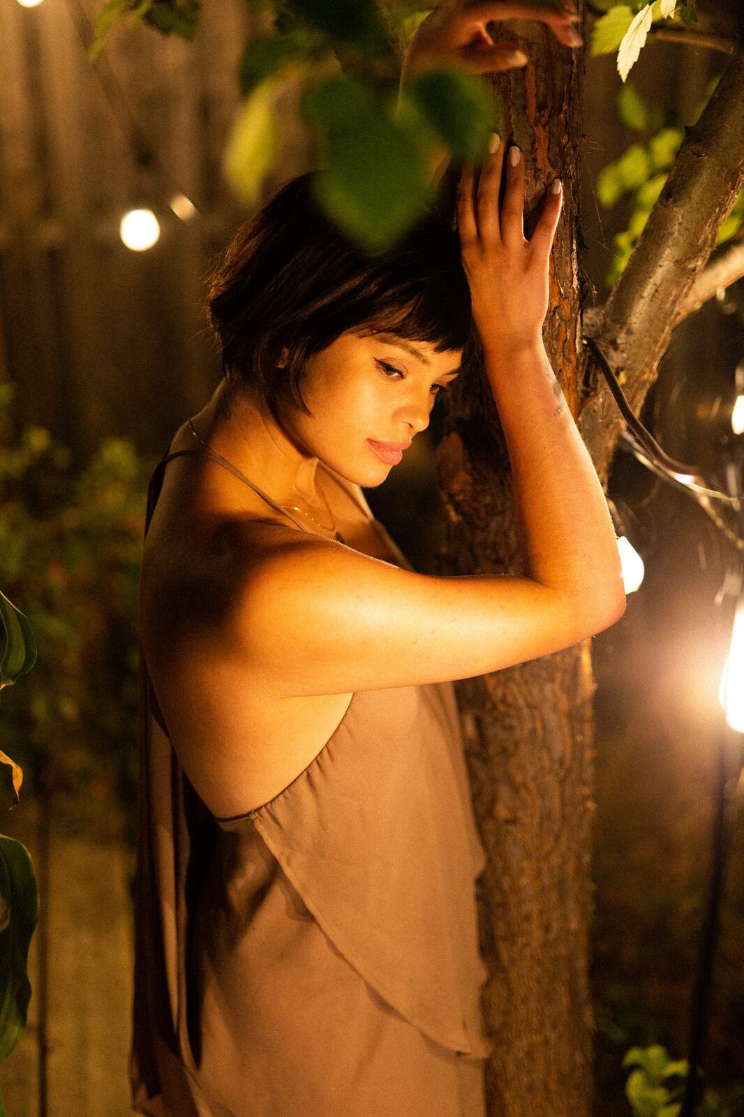 Lucy at the Water’s Edge portraits story frame 25: Lucy at the water’s edge as sunset slips into moonlight, moving from the shoreline and rocks to quiet close portraits and a warm-lit garden after dark. Photographed in Kelowna, BC.
