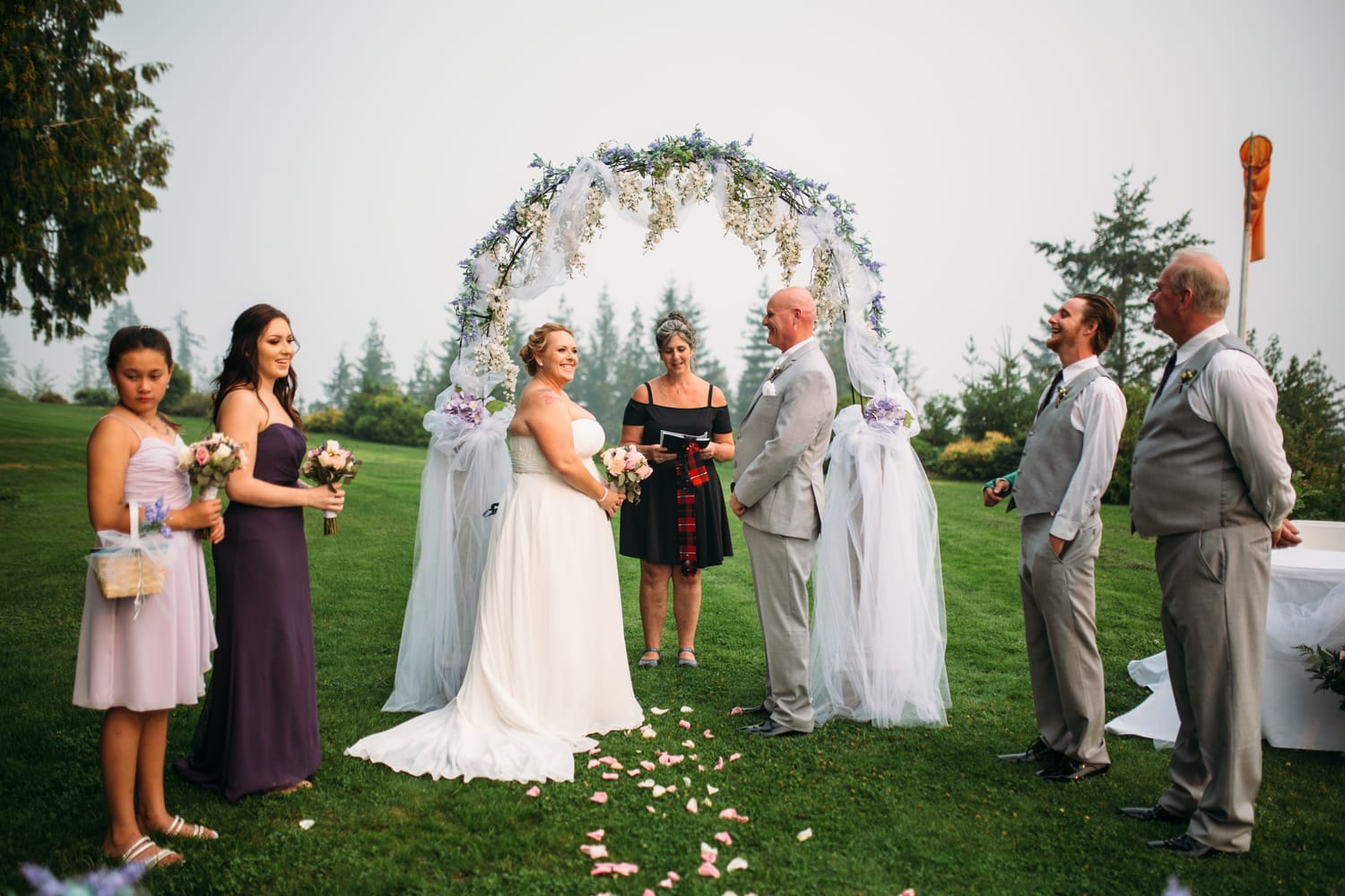 Marie and Mark weddings story frame 18: A Mabel Lake Airpark wedding in the North Okanagan, with grass-runway scenery, open-air photos and sweet family help around makeup, flowers and petals..