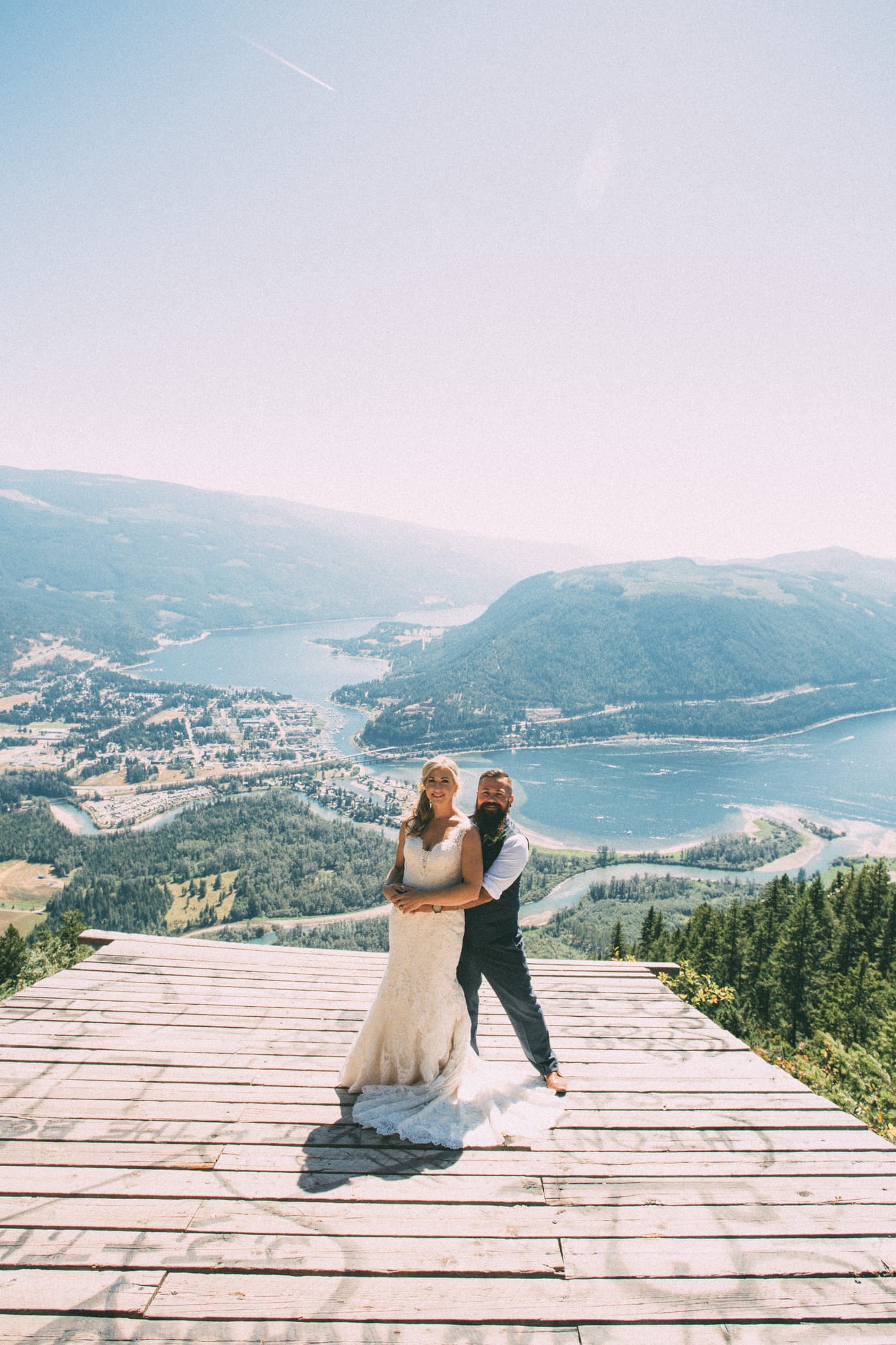Megan and Jarid weddings story frame 11: A Shuswap-area wedding around Sicamous, Swansea Point and Hyde Mountain, with boat/lake context, cliff portraits and strong floral colour..