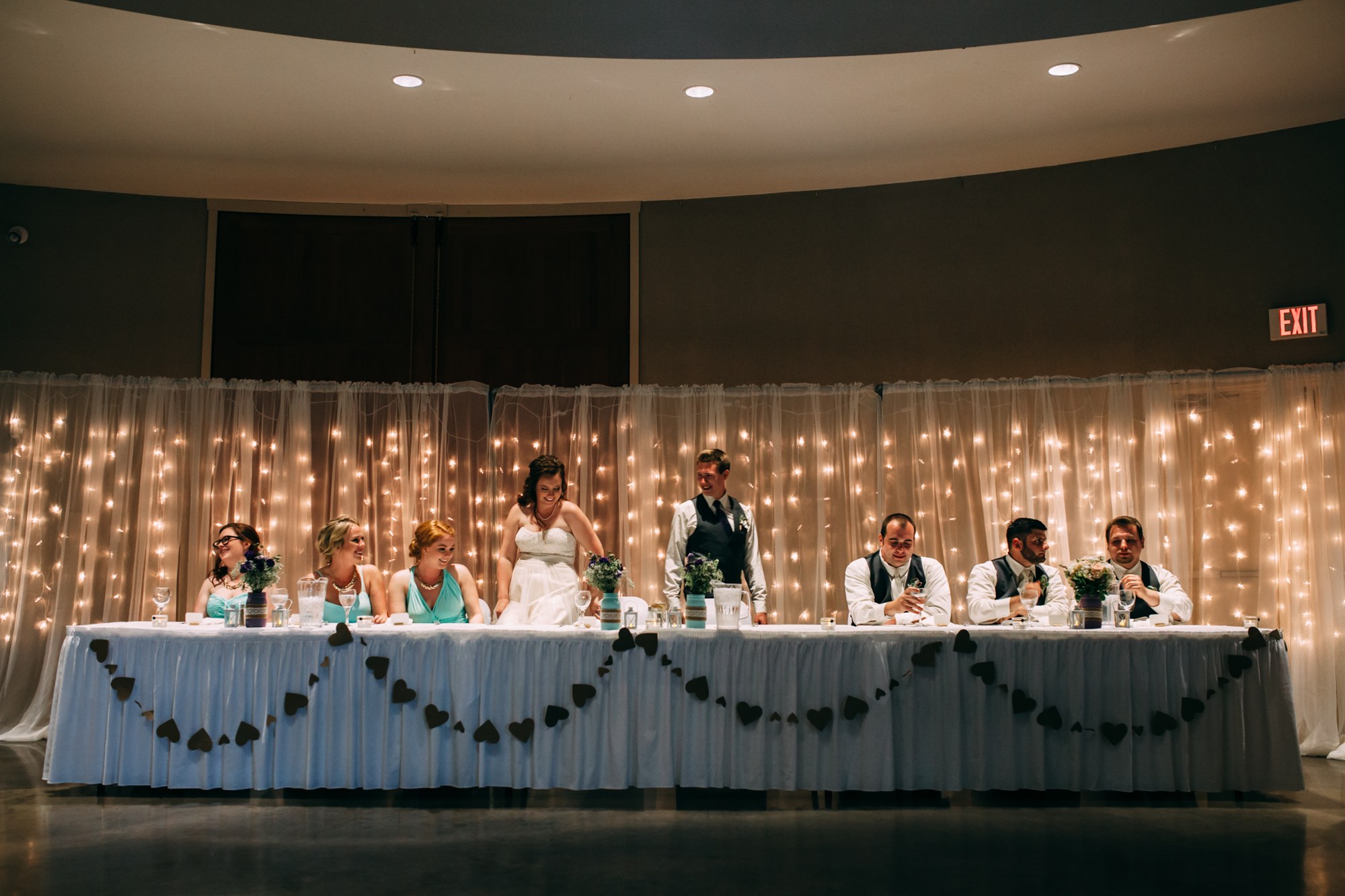 Mel & Eric: The couple and wedding party at the reception table.