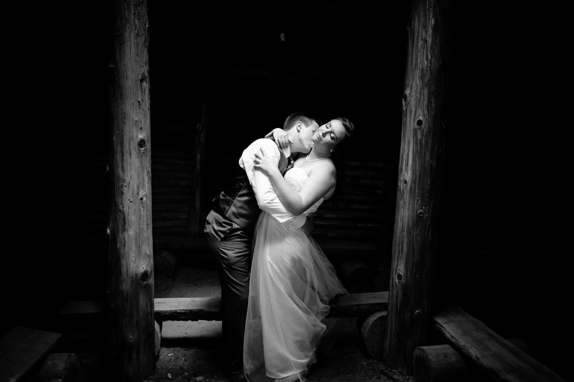 Mel and Eric embracing in a black-and-white wedding portrait.