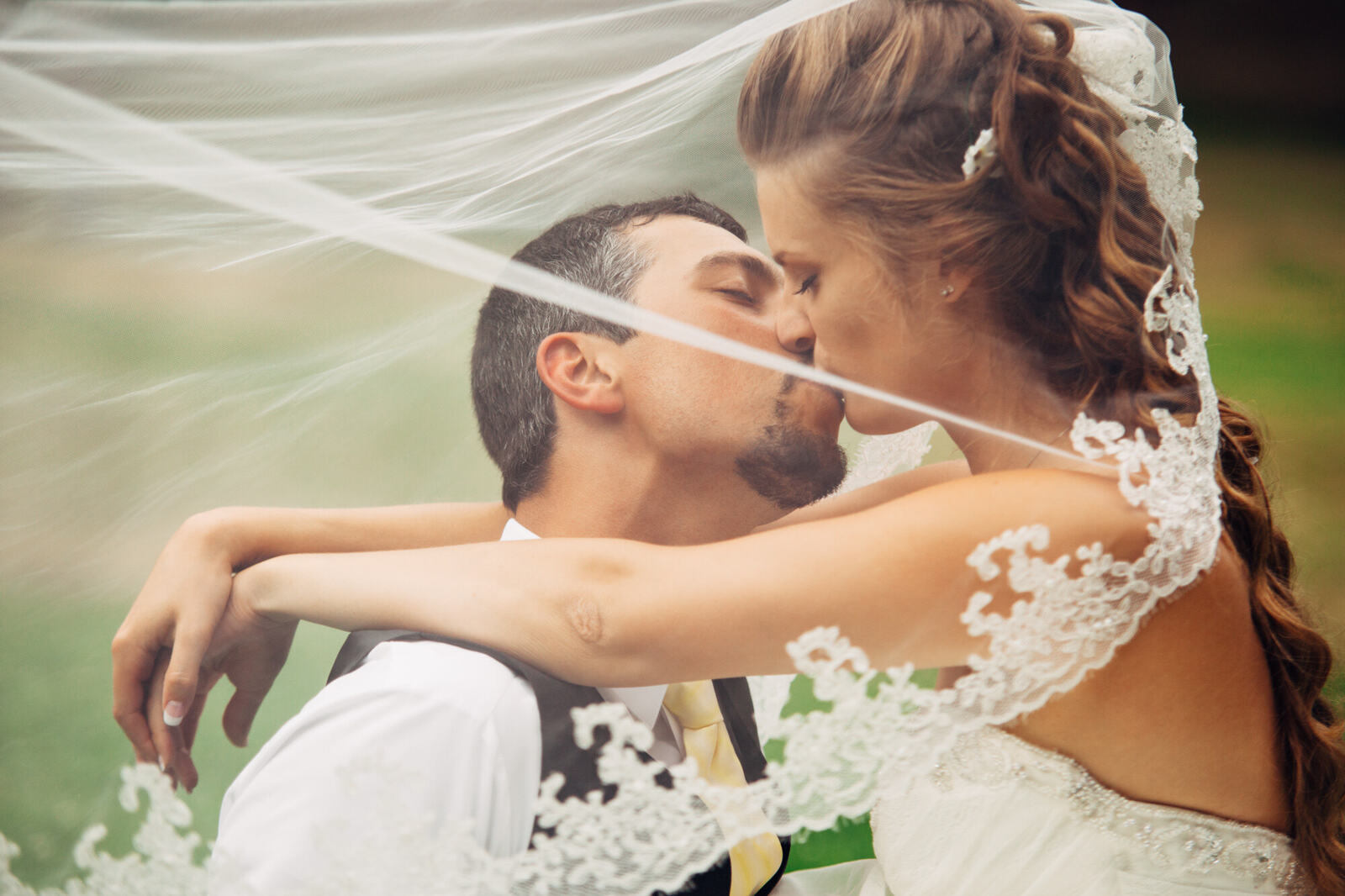 Close portrait of Mel and Blaise beneath the veil