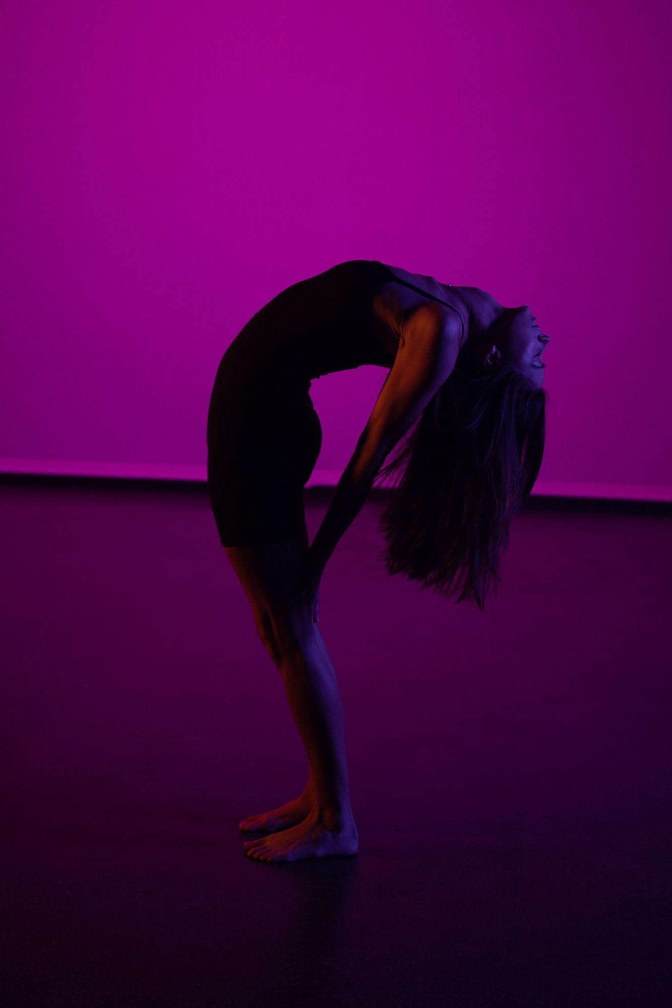 Our Yoga Space Studio Portraits: Arched standing pose against pink light.