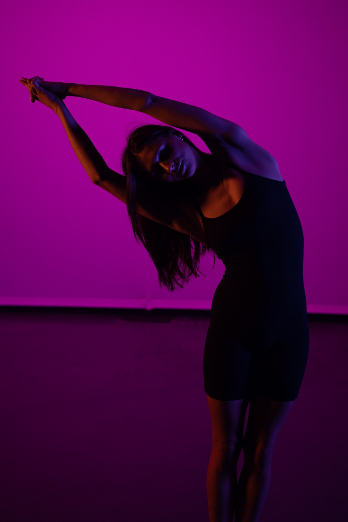 Our Yoga Space Studio Portraits: Side-bending silhouette against the pink backdrop.