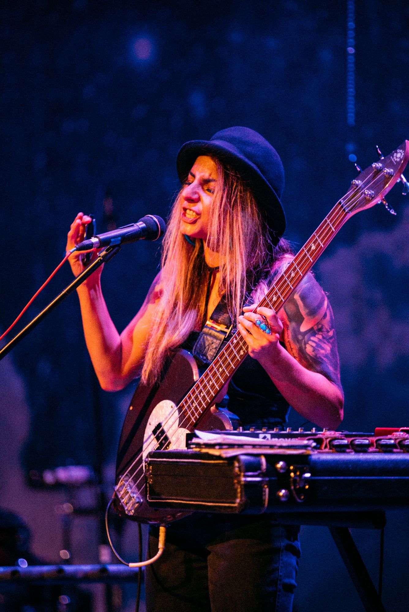 Blonde MusicBC performer singing with bass and electronic setup.