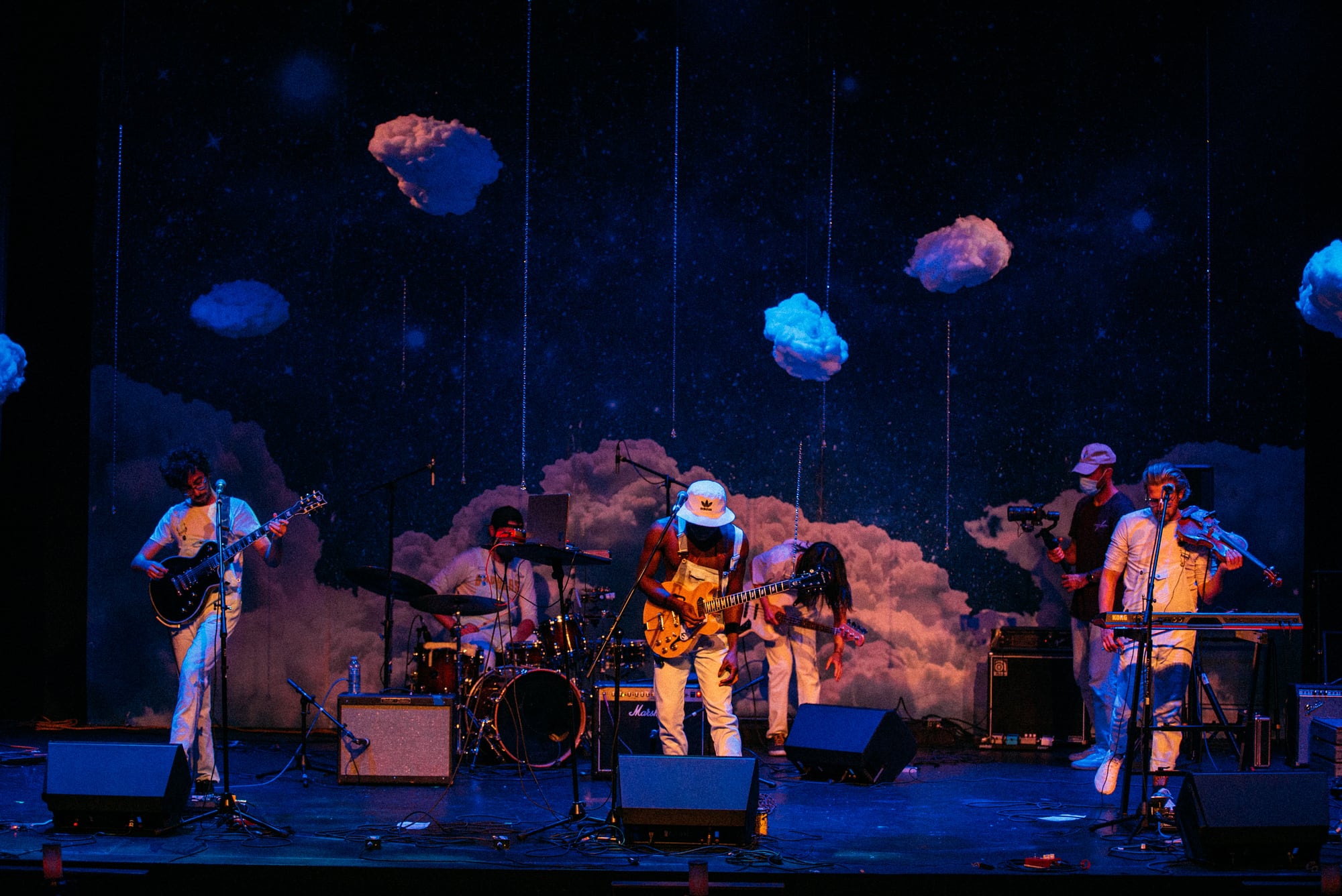 Full-stage view of a band performing under blue lights.