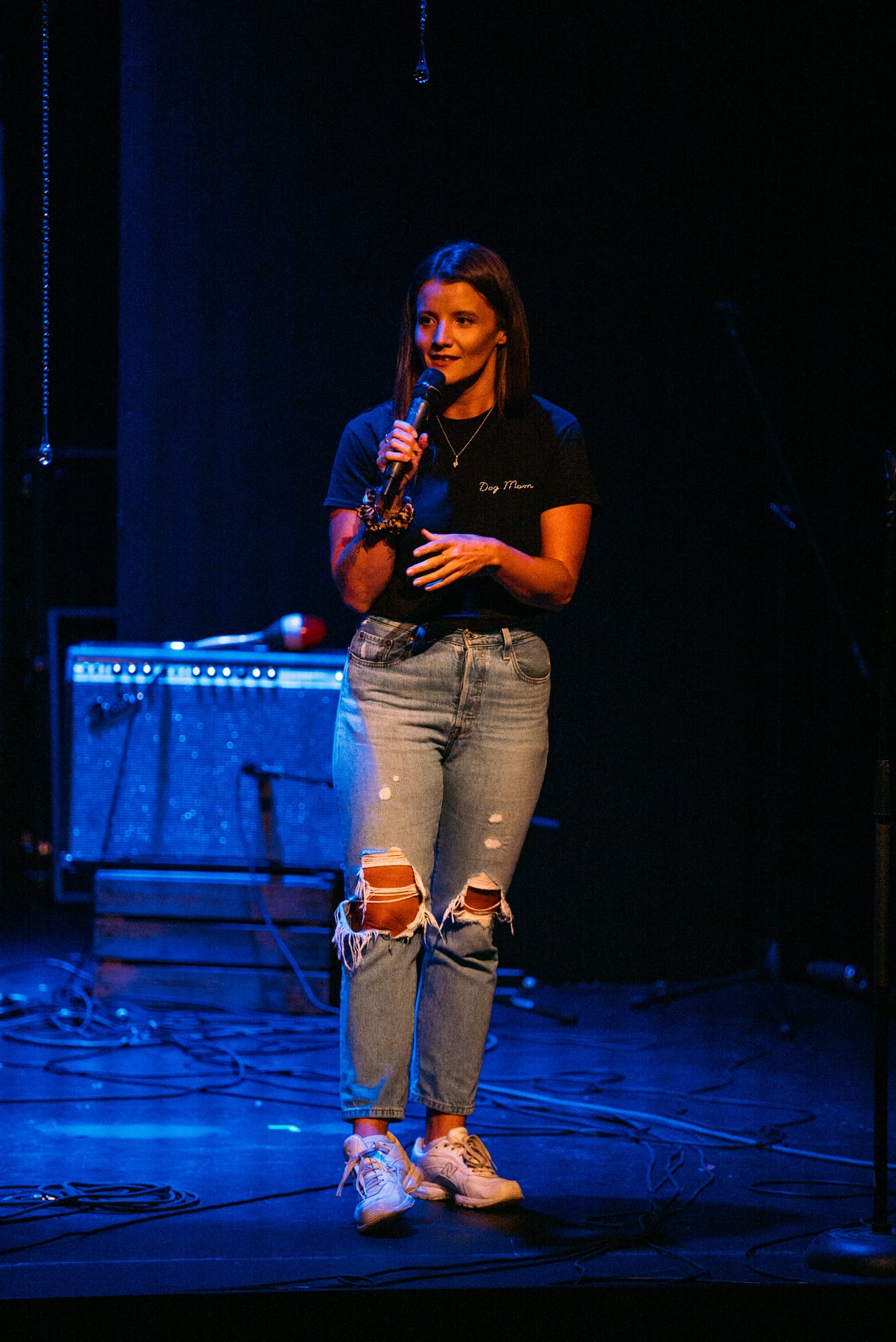 Host standing alone at microphone between band sets.