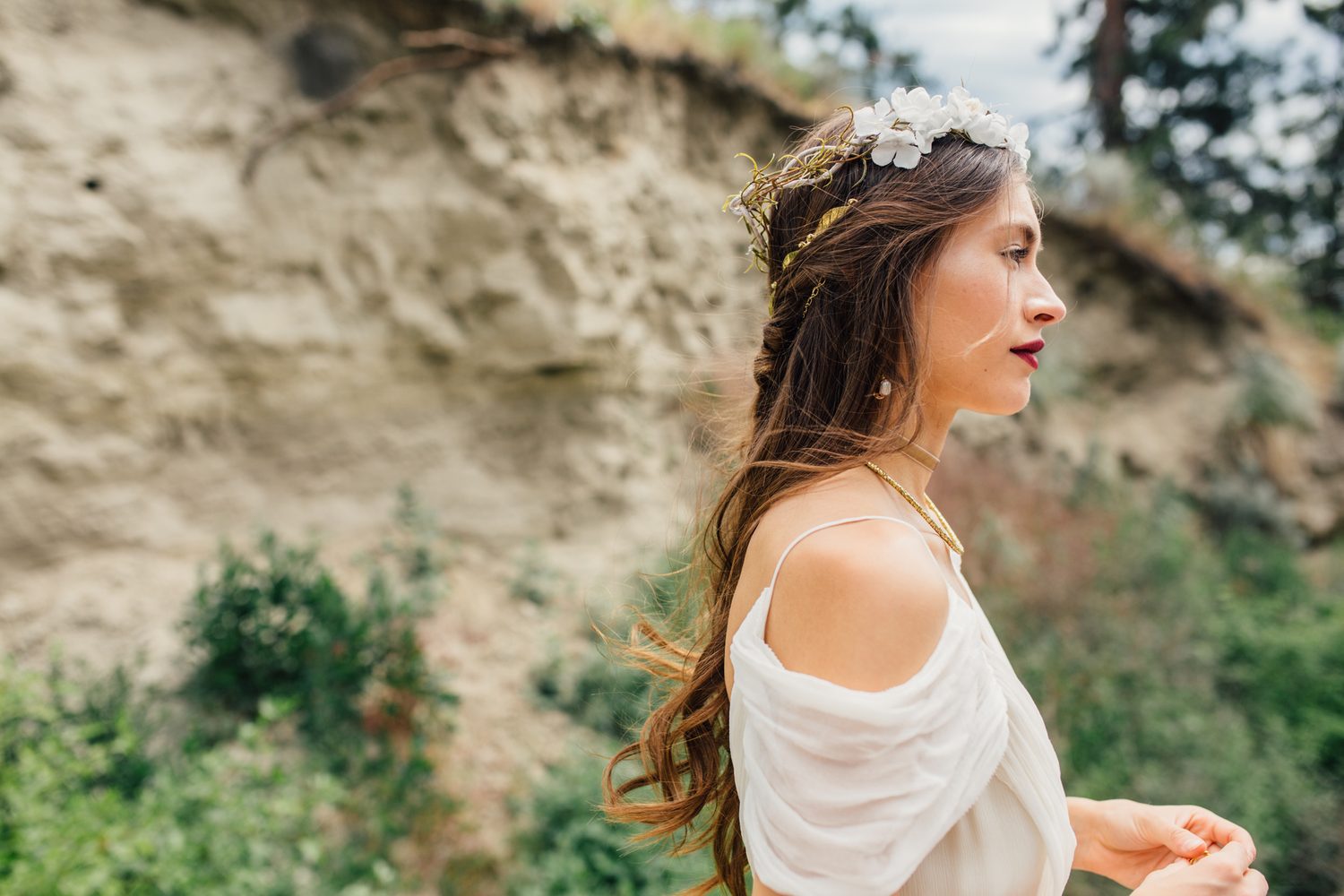 Nicole, White Willow portraits story frame 10: Nicole in a White Willow Photography-designed bridal editorial near Salmon Arm, moving from rock-face portraits through bouquet, veil and flower-crown details.