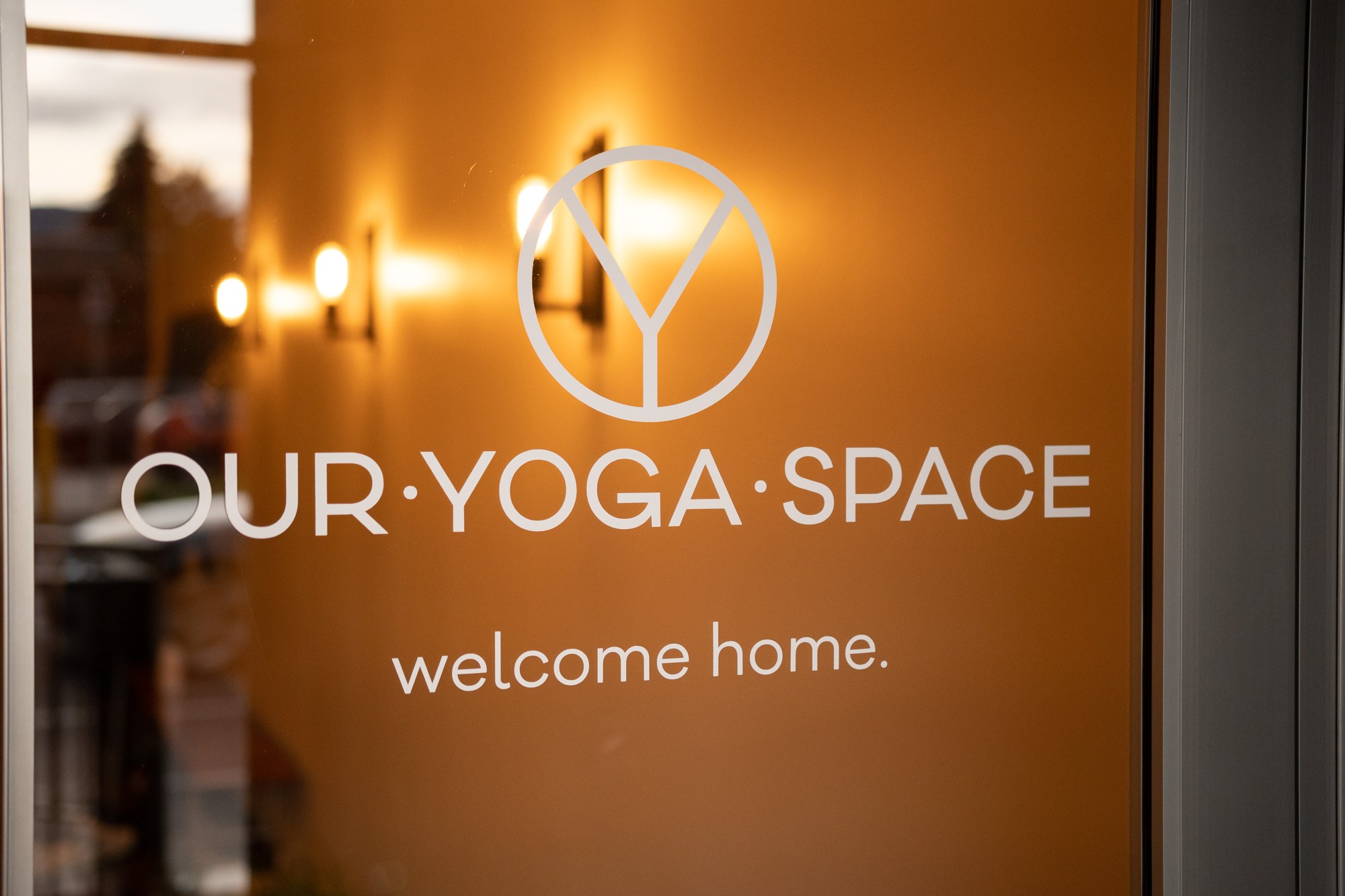Our Yoga Space Turns Three: Our Yoga Space branding on the warmly lit entrance.