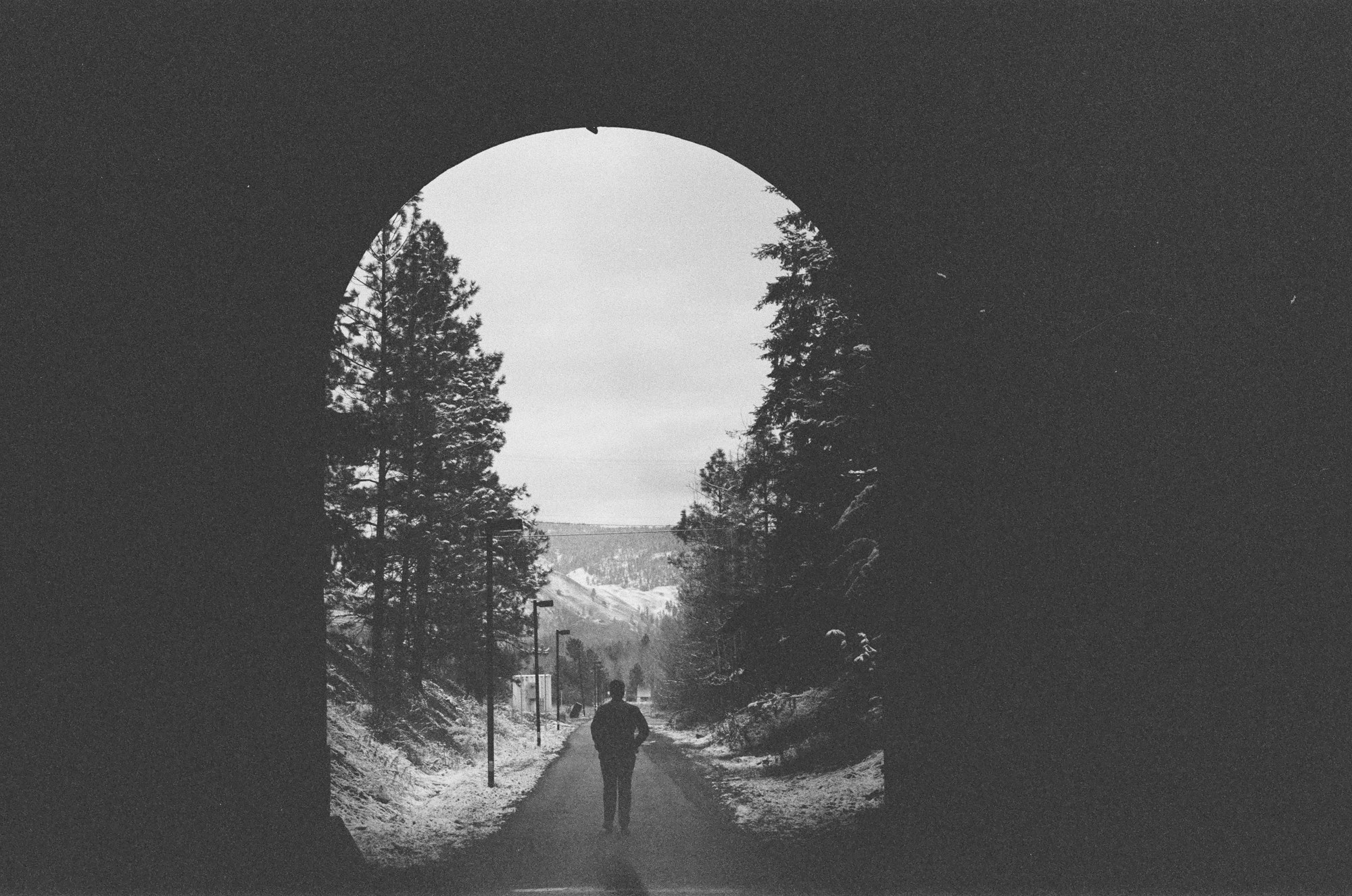 A small figure beneath the Princeton tunnel arch in black and white.