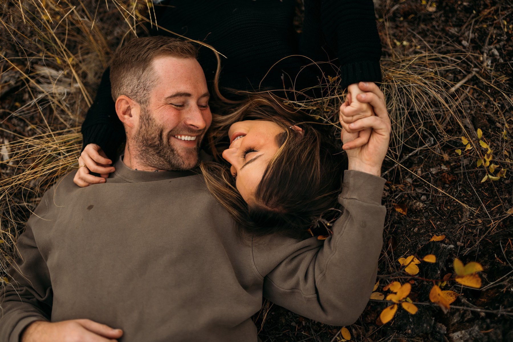 Rachel and Ryan portraits story frame 5: Okanagan couples portraits with dirt bikes, lake and mountain views, autumn sun, standing portraits and champagne celebration.