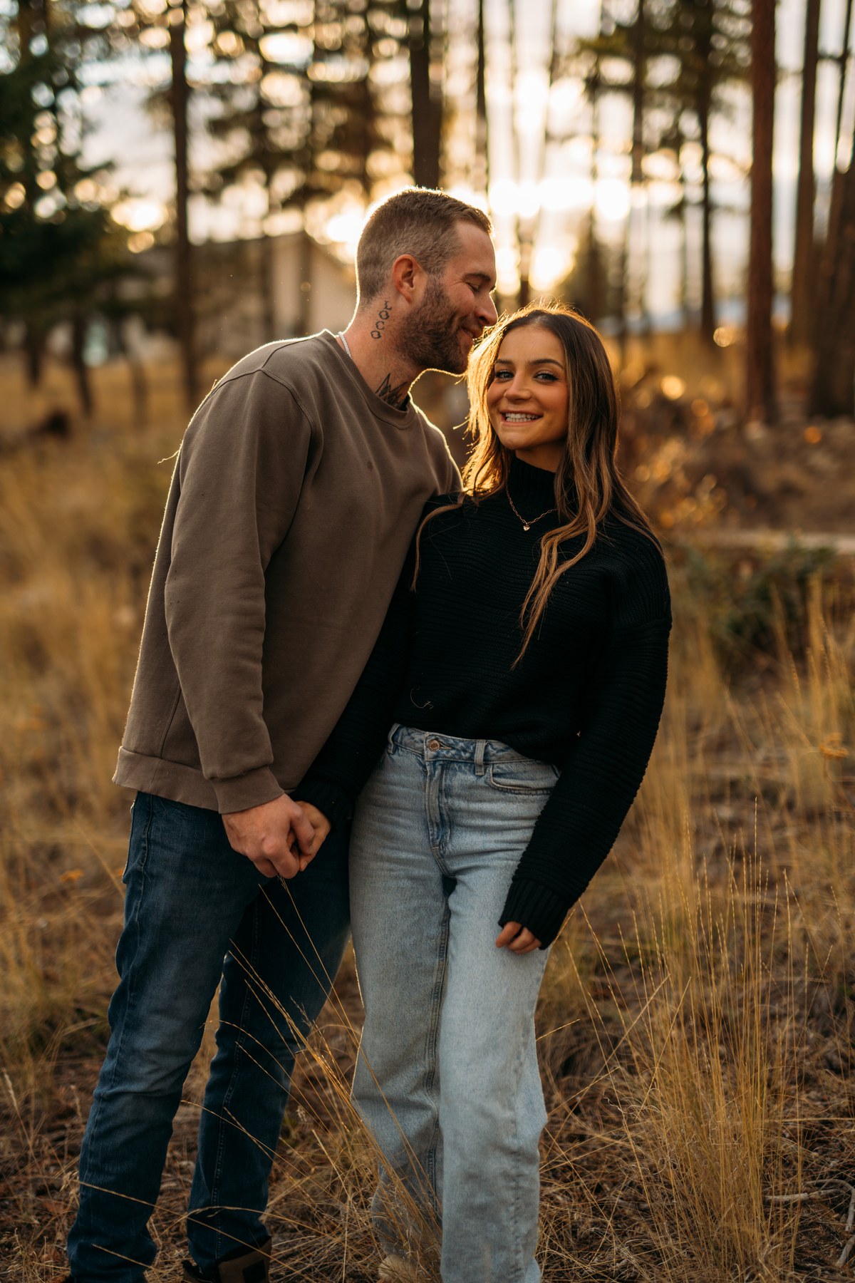 Rachel and Ryan portraits story frame 7: Okanagan couples portraits with dirt bikes, lake and mountain views, autumn sun, standing portraits and champagne celebration.