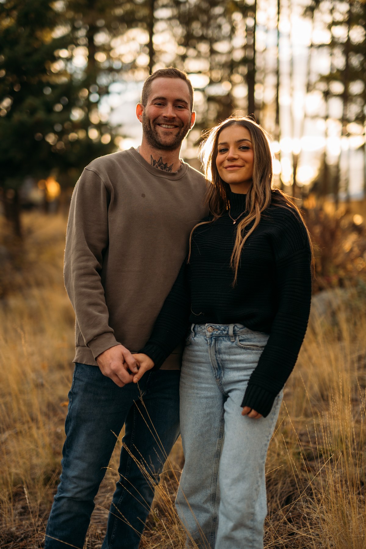 Rachel and Ryan portraits story frame 8: Okanagan couples portraits with dirt bikes, lake and mountain views, autumn sun, standing portraits and champagne celebration.