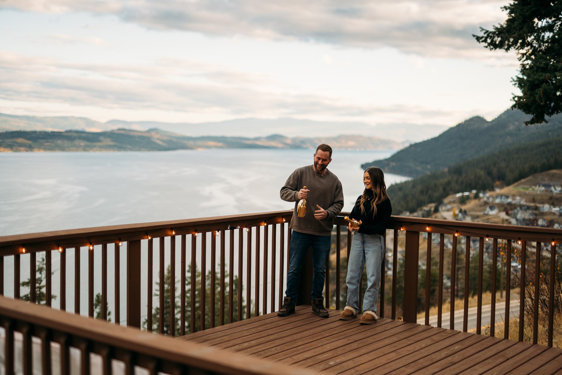 Rachel and Ryan portraits story frame 10: Okanagan couples portraits with dirt bikes, lake and mountain views, autumn sun, standing portraits and champagne celebration.