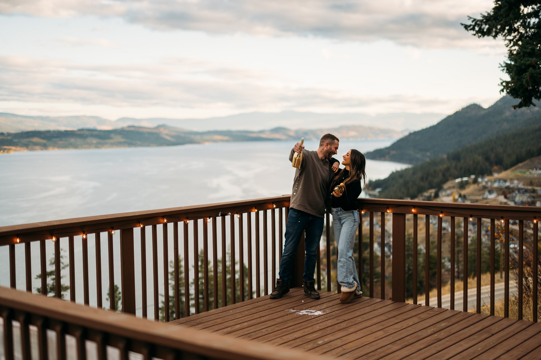 Rachel and Ryan portraits story frame 11: Okanagan couples portraits with dirt bikes, lake and mountain views, autumn sun, standing portraits and champagne celebration.