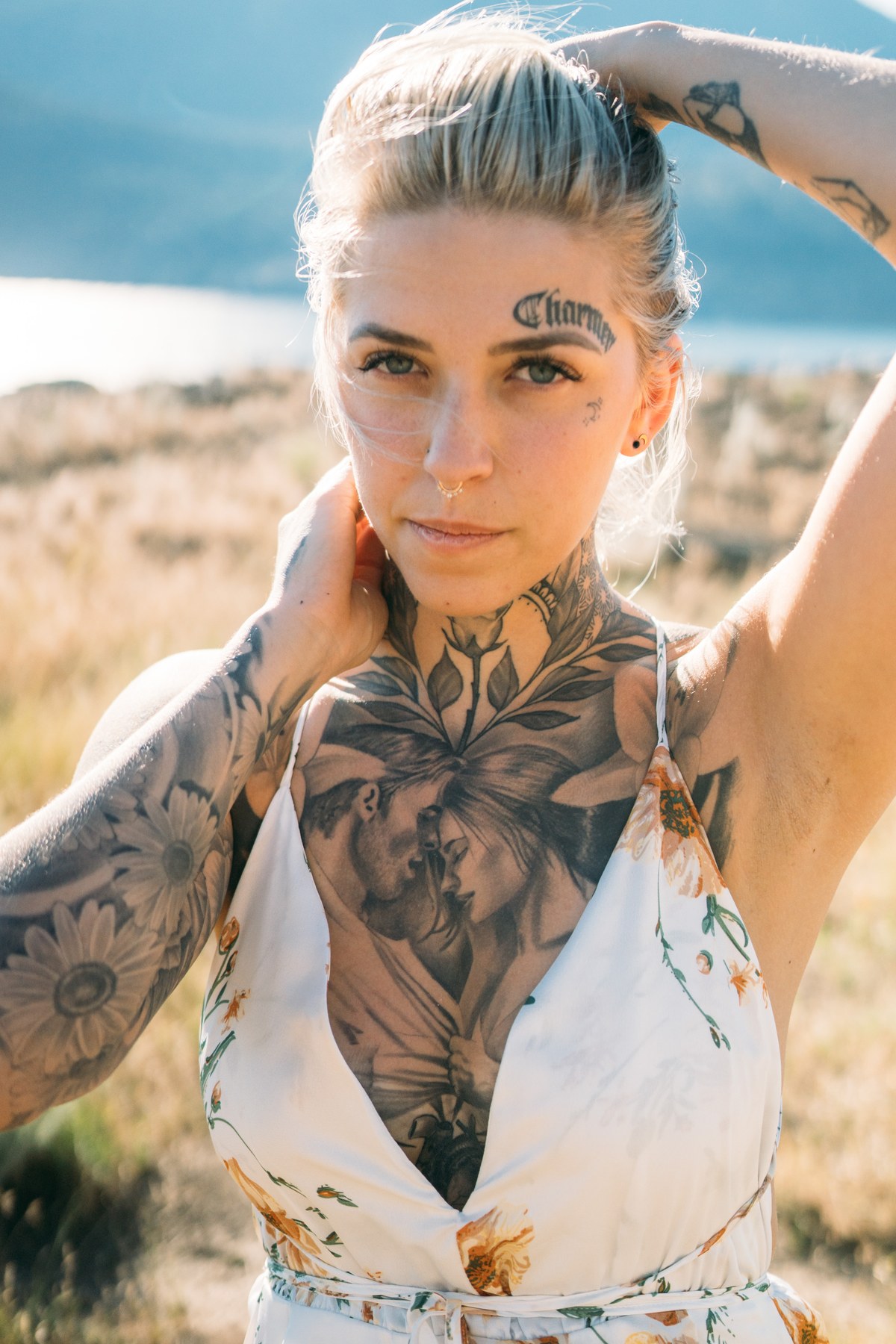 Rayleigh by Knox portraits story frame 2: Knox Mountain portraits in Kelowna with white floral dress, tattoo detail, reeds, water, sunlight and a stronger summer edge.