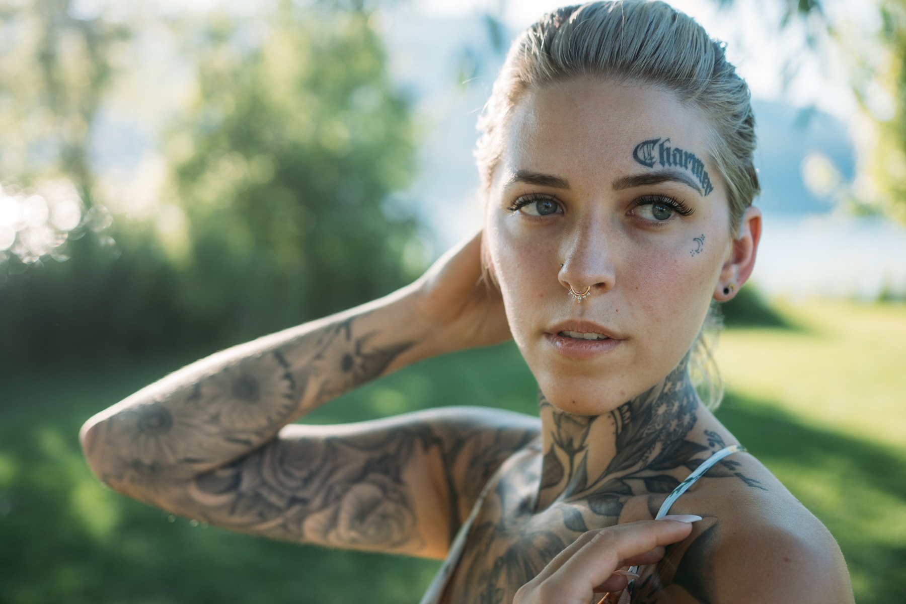 Rayleigh by Knox portraits story frame 3: Knox Mountain portraits in Kelowna with white floral dress, tattoo detail, reeds, water, sunlight and a stronger summer edge.