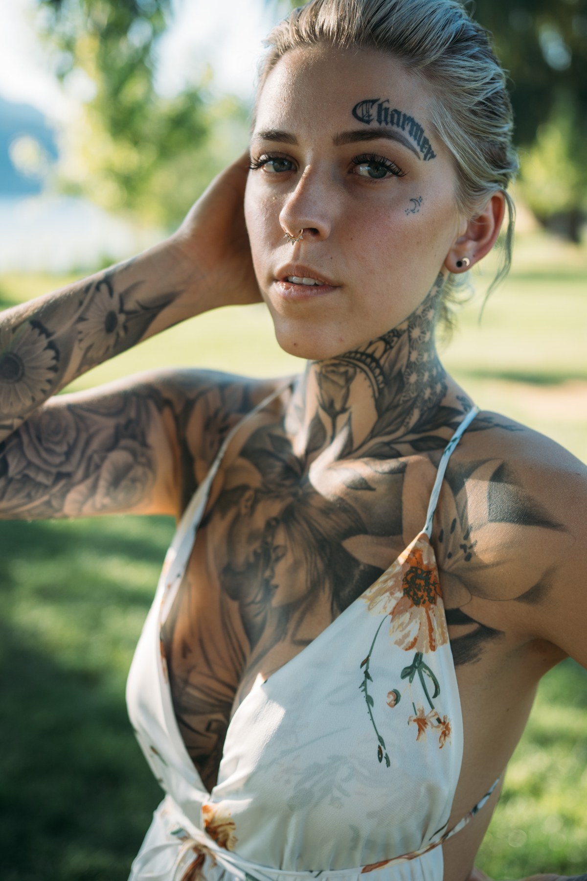 Rayleigh by Knox portraits story frame 4: Knox Mountain portraits in Kelowna with white floral dress, tattoo detail, reeds, water, sunlight and a stronger summer edge.