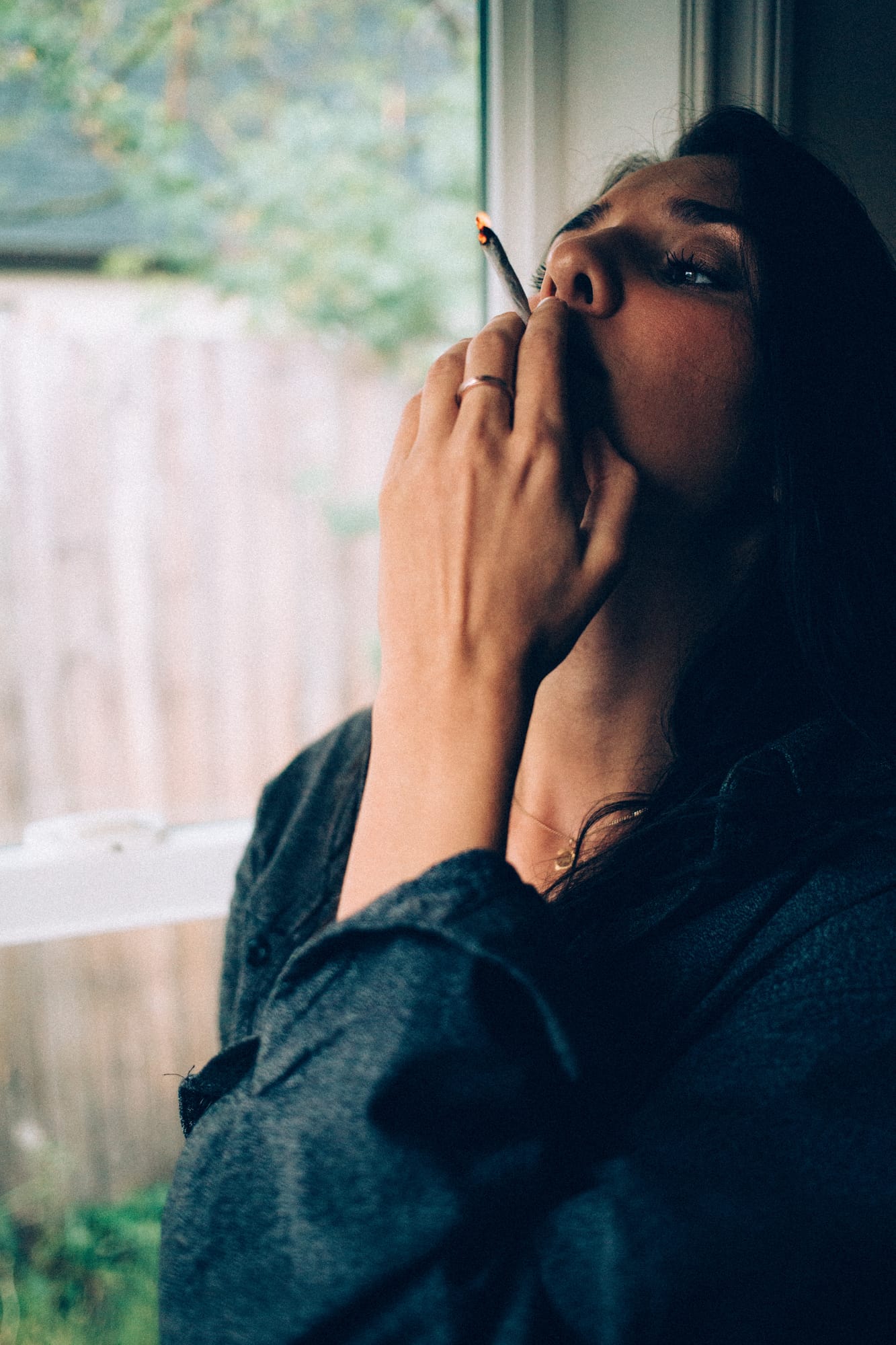Rebecca in Smoke portraits story frame 18: A dark Kelowna portrait story for Rebecca with window light, smoke, denim, close expression and a low-key editorial mood.