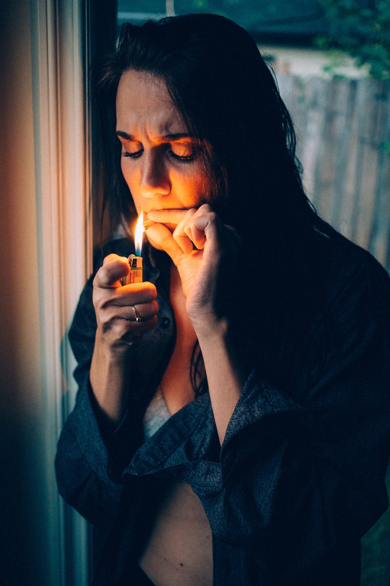 Rebecca in Smoke portraits story frame 22: A dark Kelowna portrait story for Rebecca with window light, smoke, denim, close expression and a low-key editorial mood.