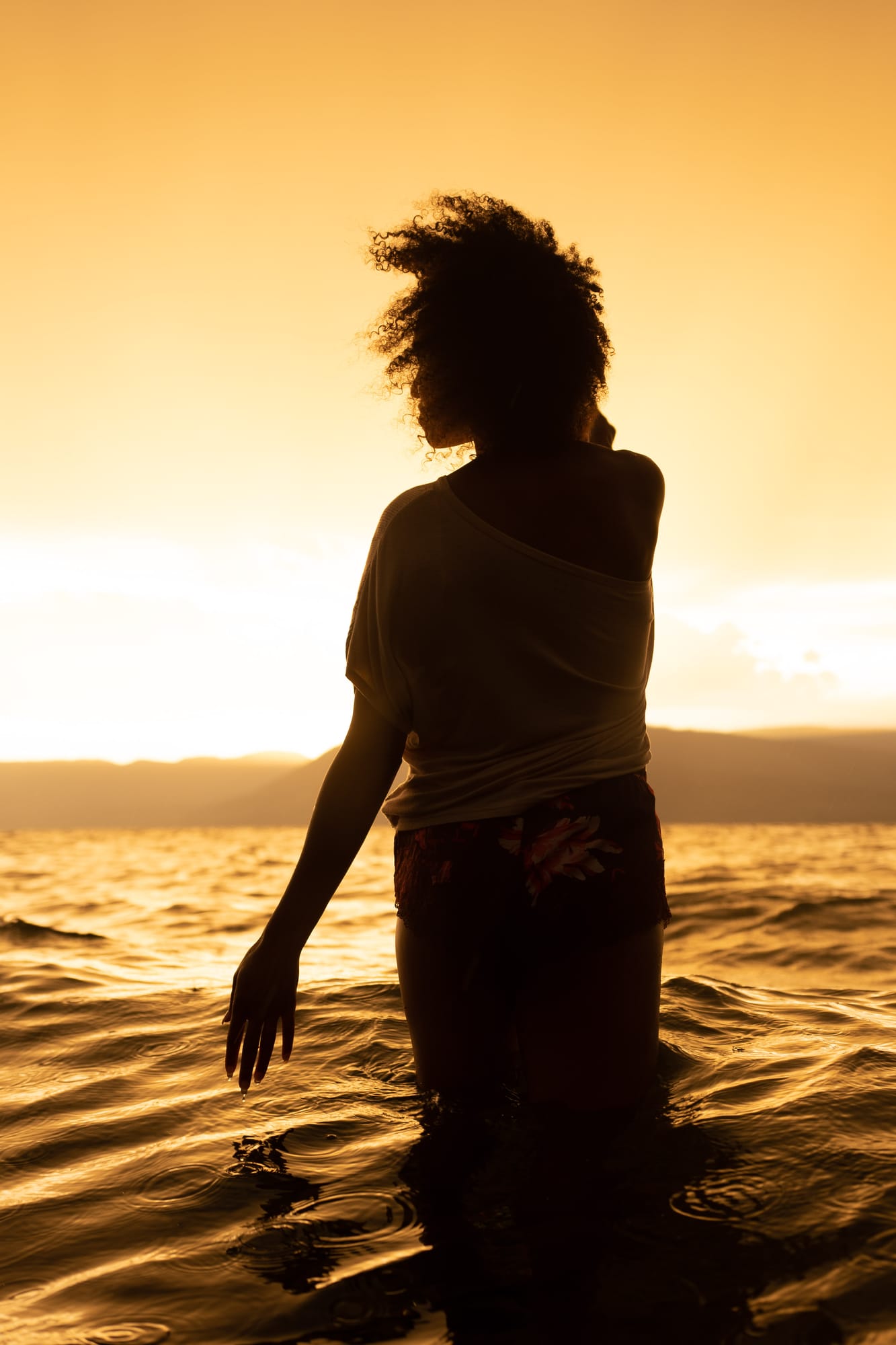 Rebekah at Bertram portraits story frame 17: A Bertram portrait story moving from floral dress and lake light into black dress, white shirt, sunset and water silhouettes..