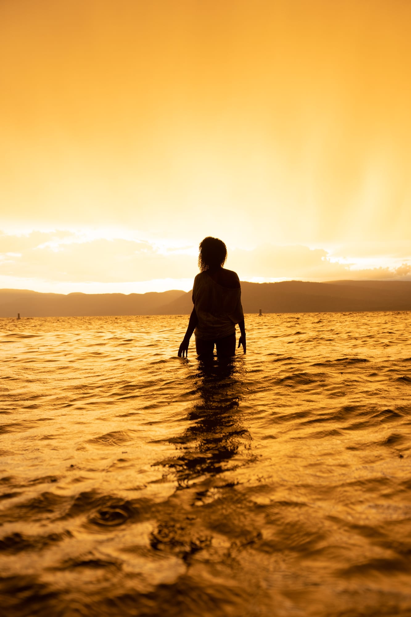 Rebekah at Bertram portraits story frame 18: A Bertram portrait story moving from floral dress and lake light into black dress, white shirt, sunset and water silhouettes..