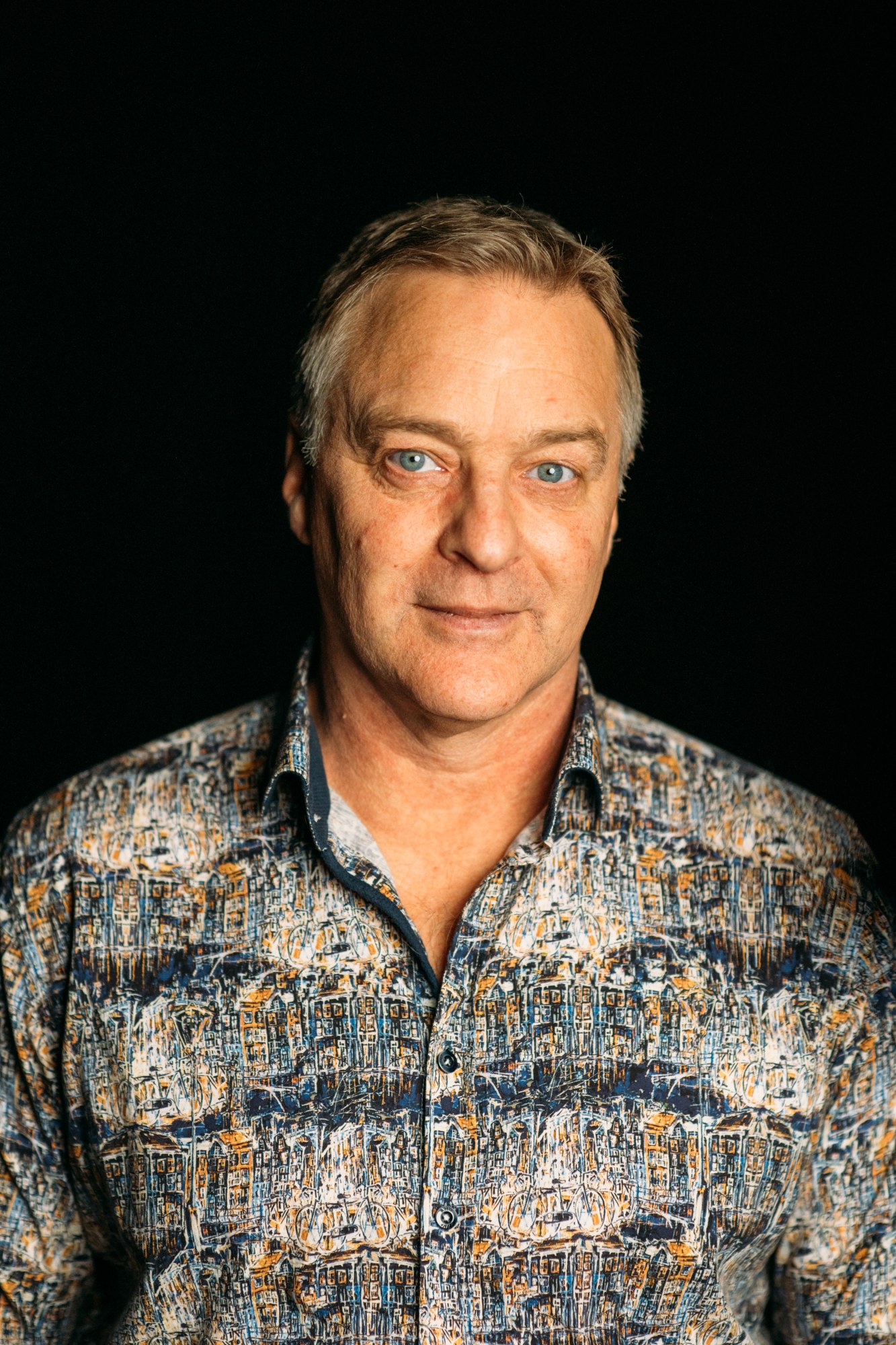 Roark looking into the camera in a patterned shirt