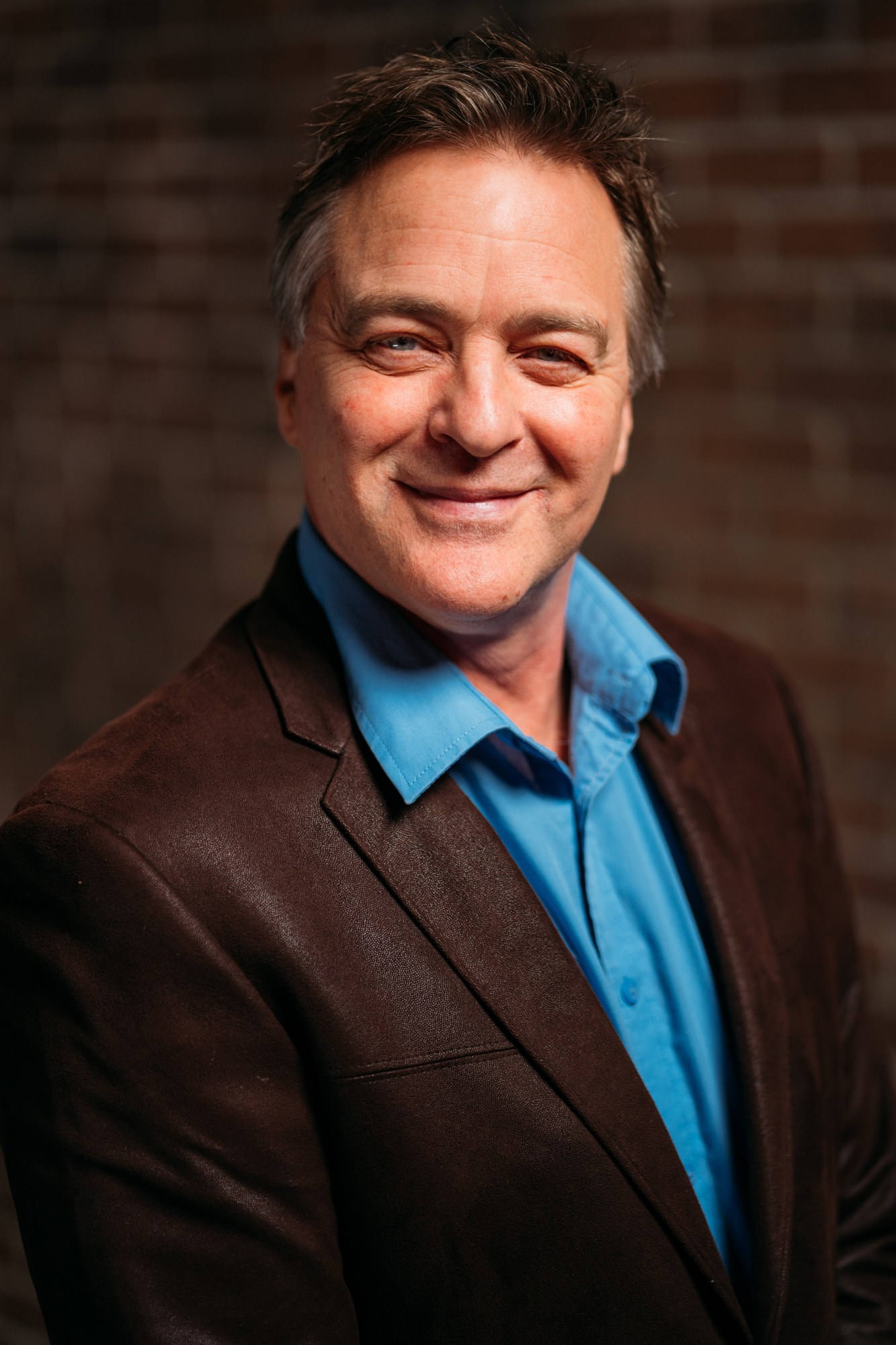 Roark smiling in a close studio portrait