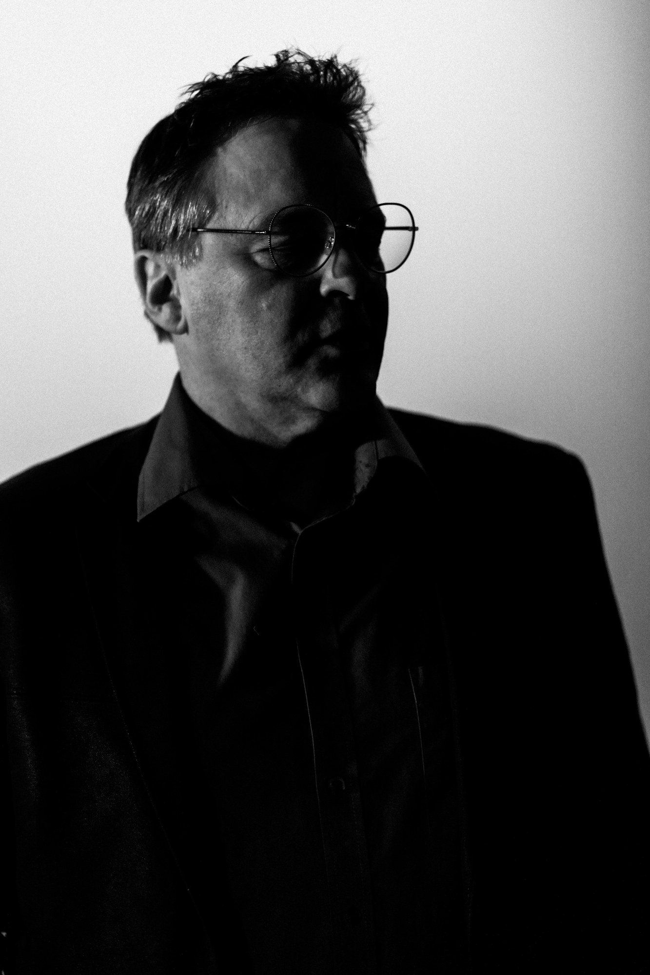 Black-and-white portrait of Roark wearing glasses