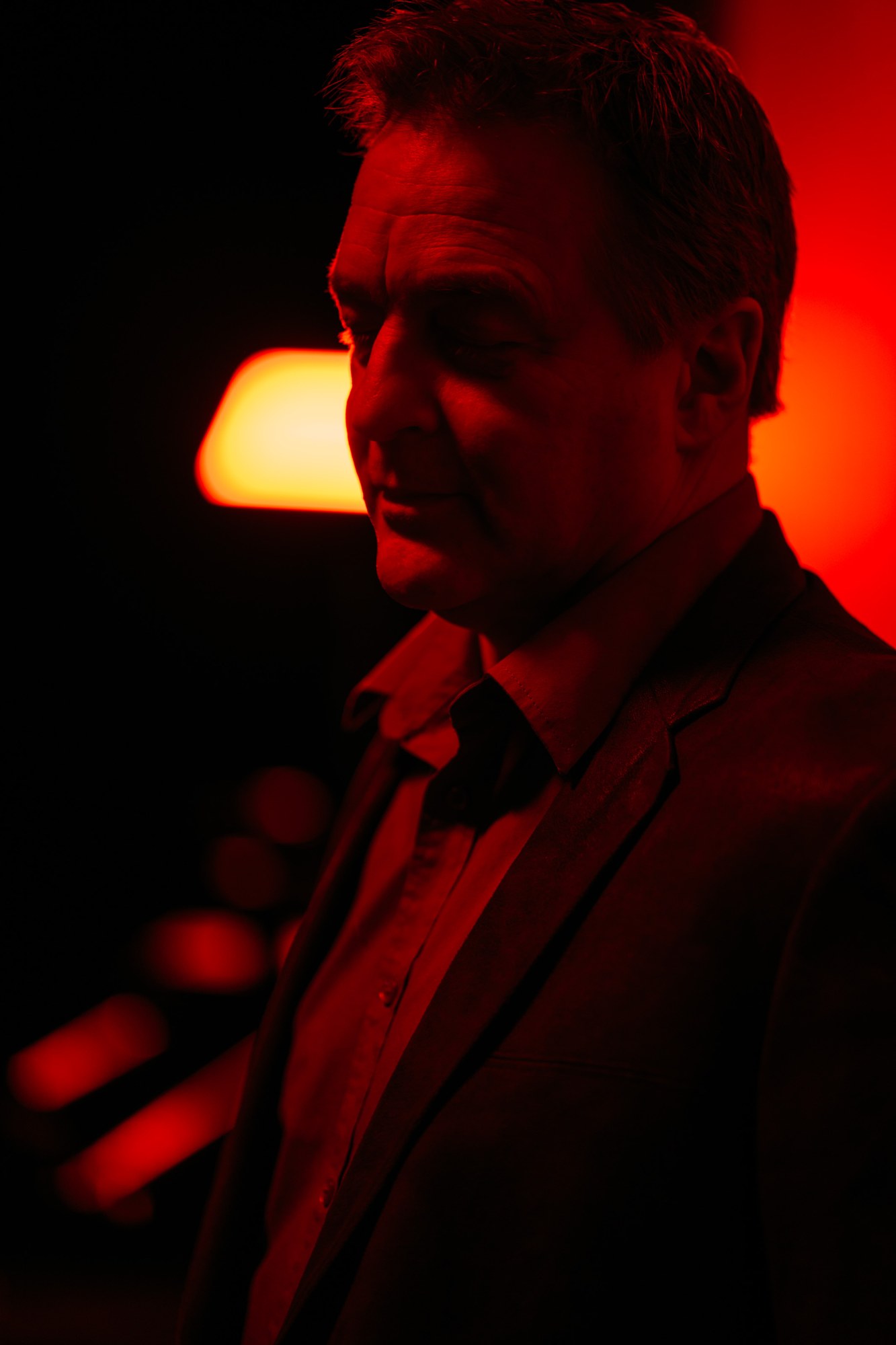 Roark lit in red beside a warm lamp