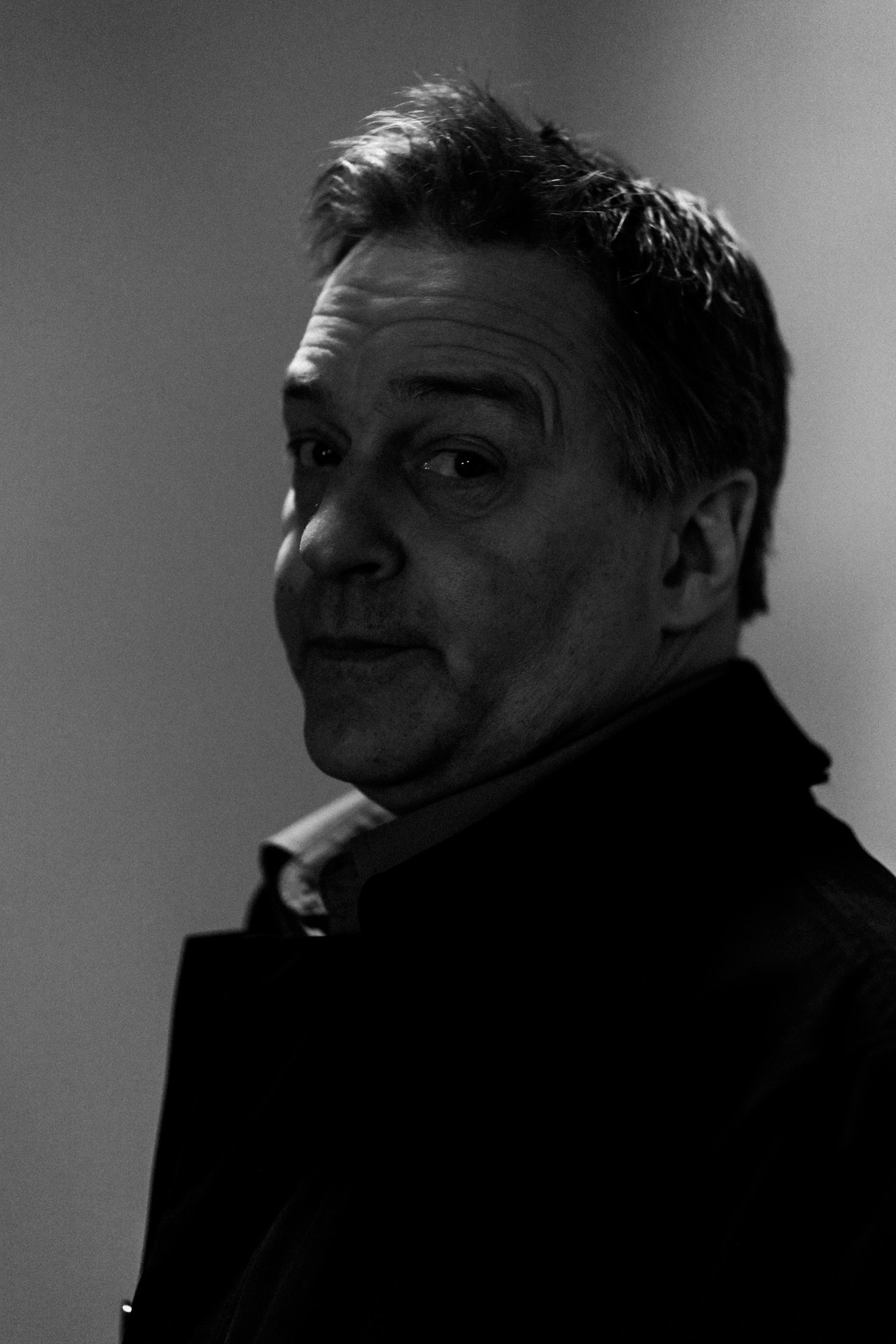 Roark looking over his shoulder in a black-and-white portrait