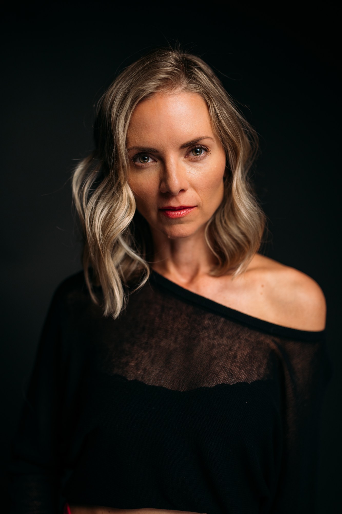 Sarah Smith-Podollan looking into the camera against a black backdrop