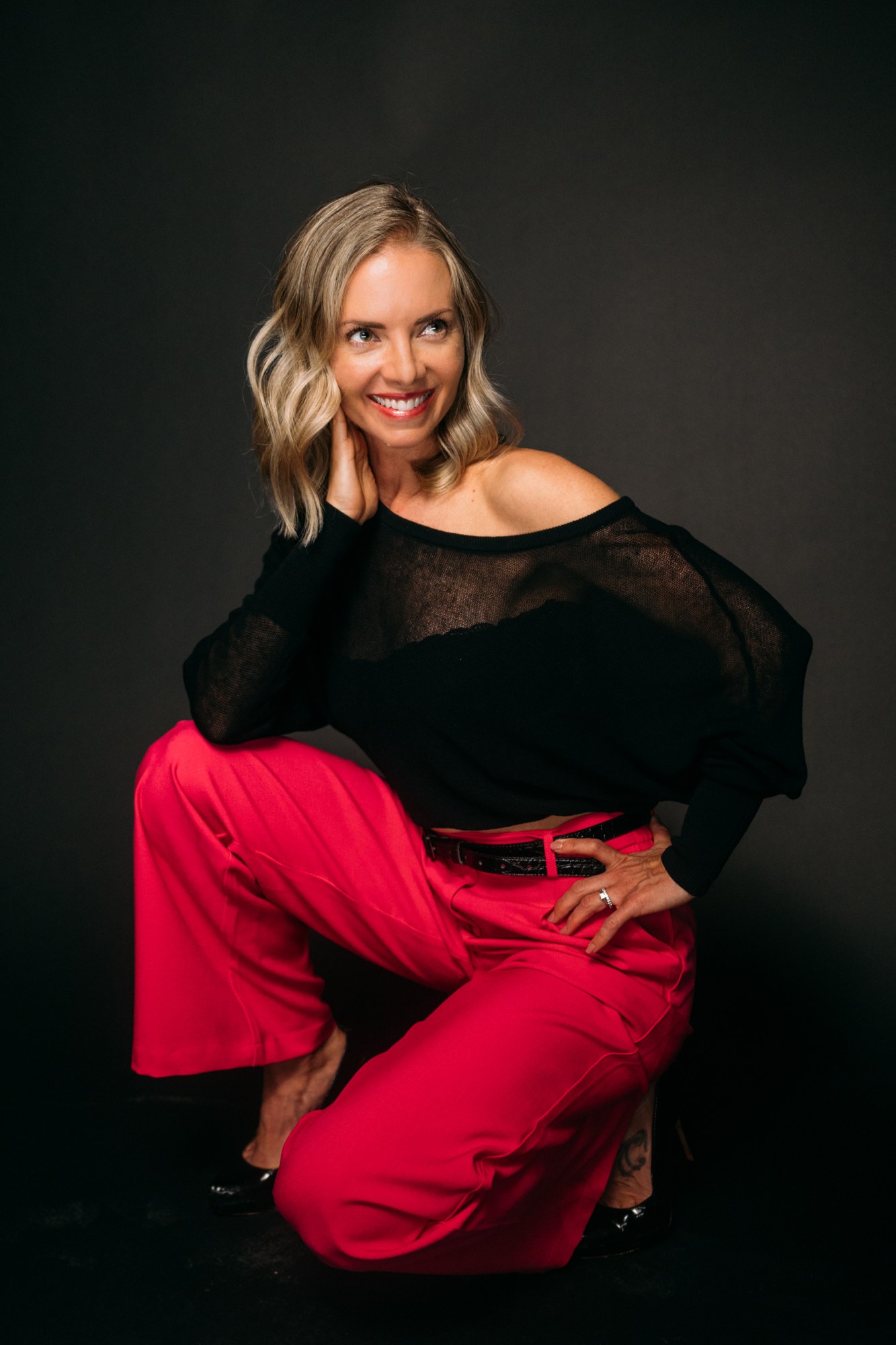 Sarah smiling in a seated studio portrait