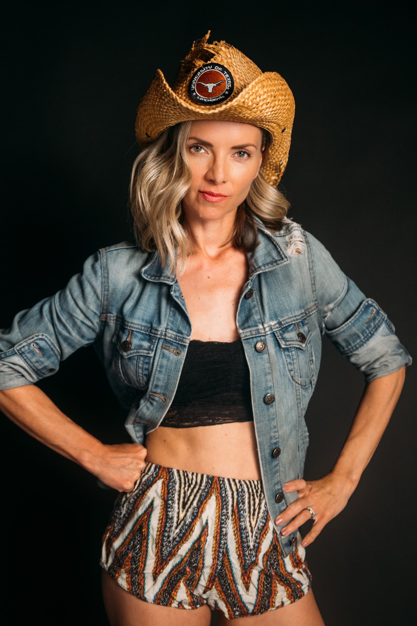Sarah in a cowboy hat and denim jacket against black