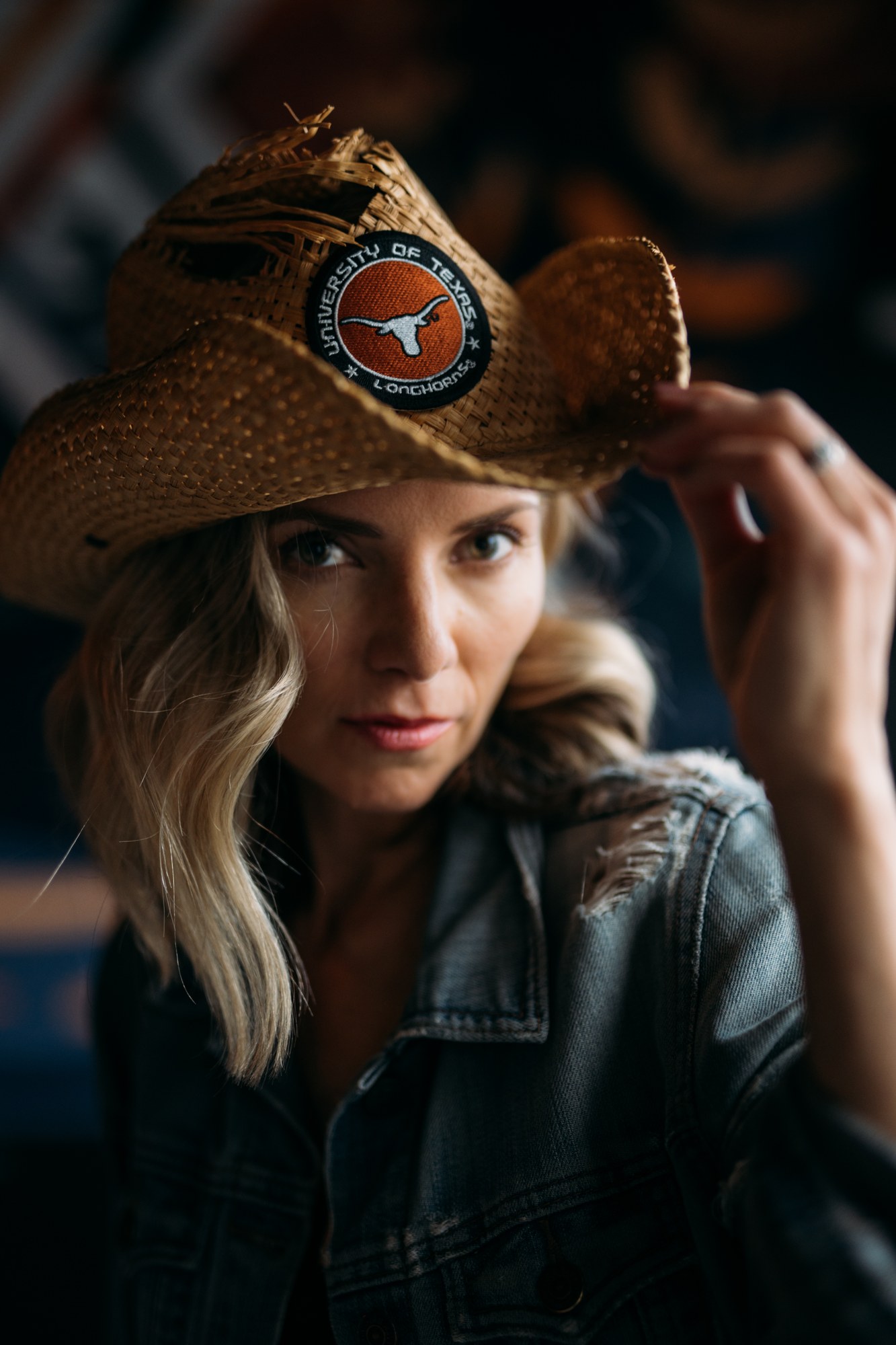 Sarah holding the brim of her cowboy hat in a close portrait
