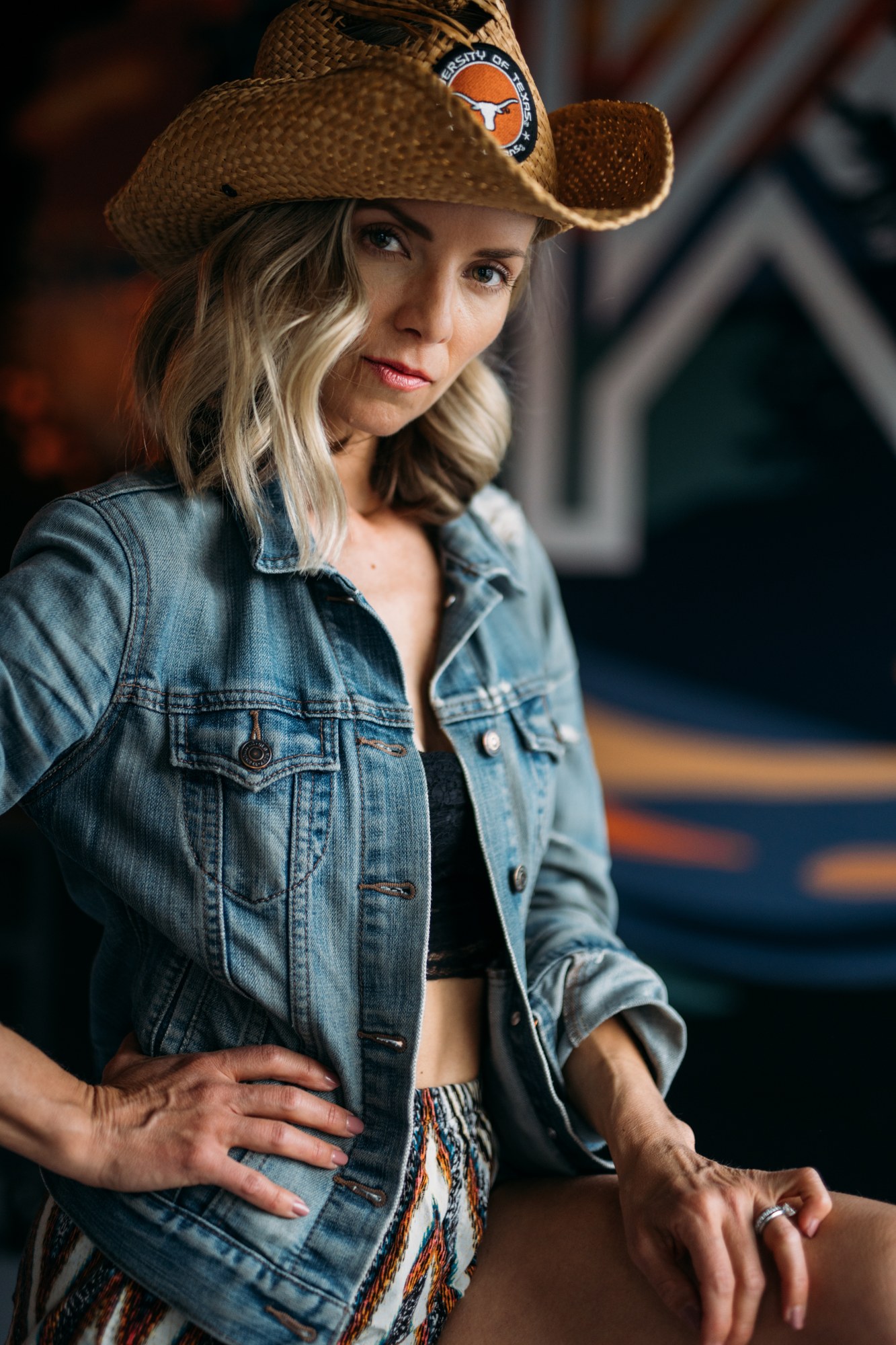 Sarah seated beside a stool with a mural behind her