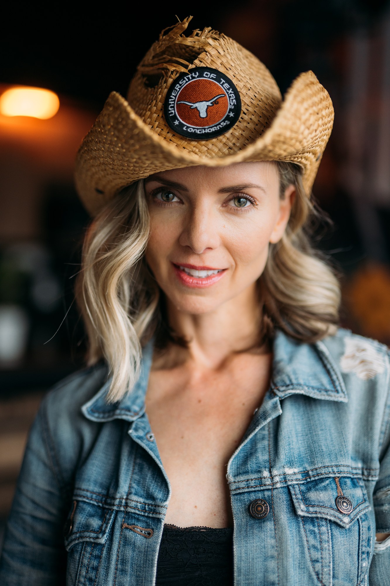 Window-lit headshot of Sarah in a cowboy hat