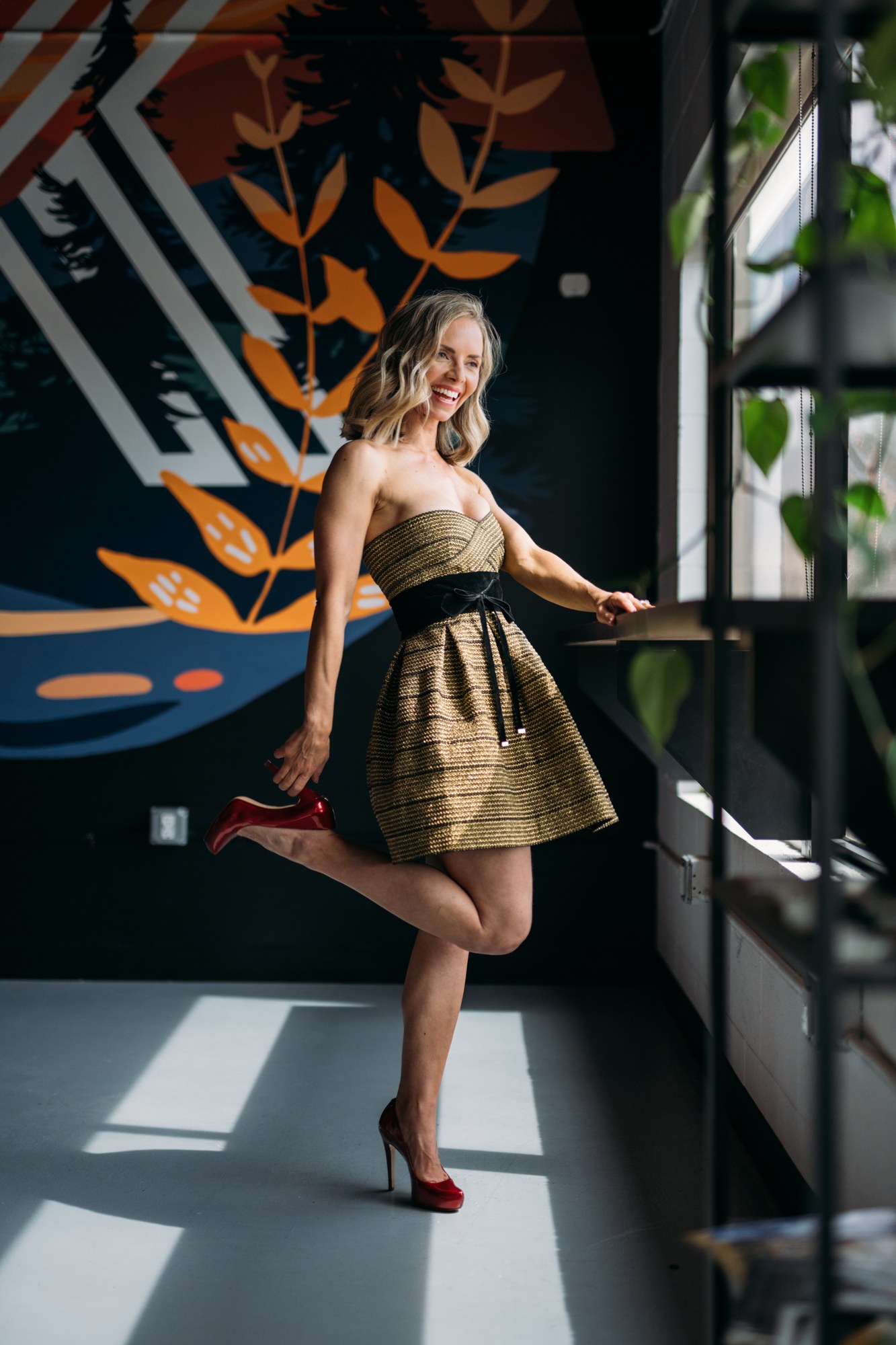 Sarah dancing beside the windows in a gold dress