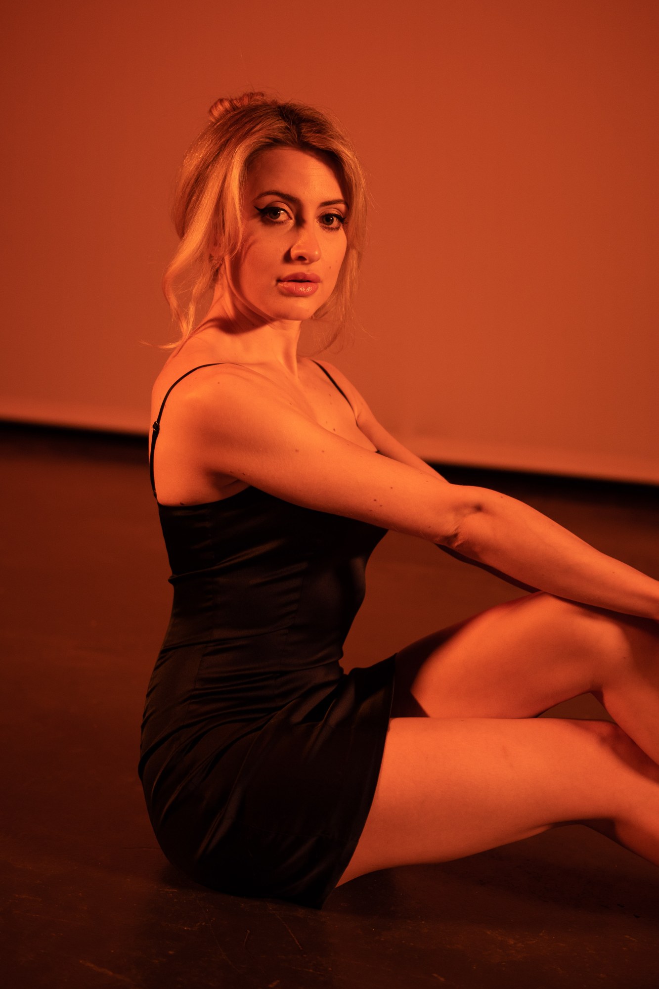 Shanelle seated on the floor in a black dress